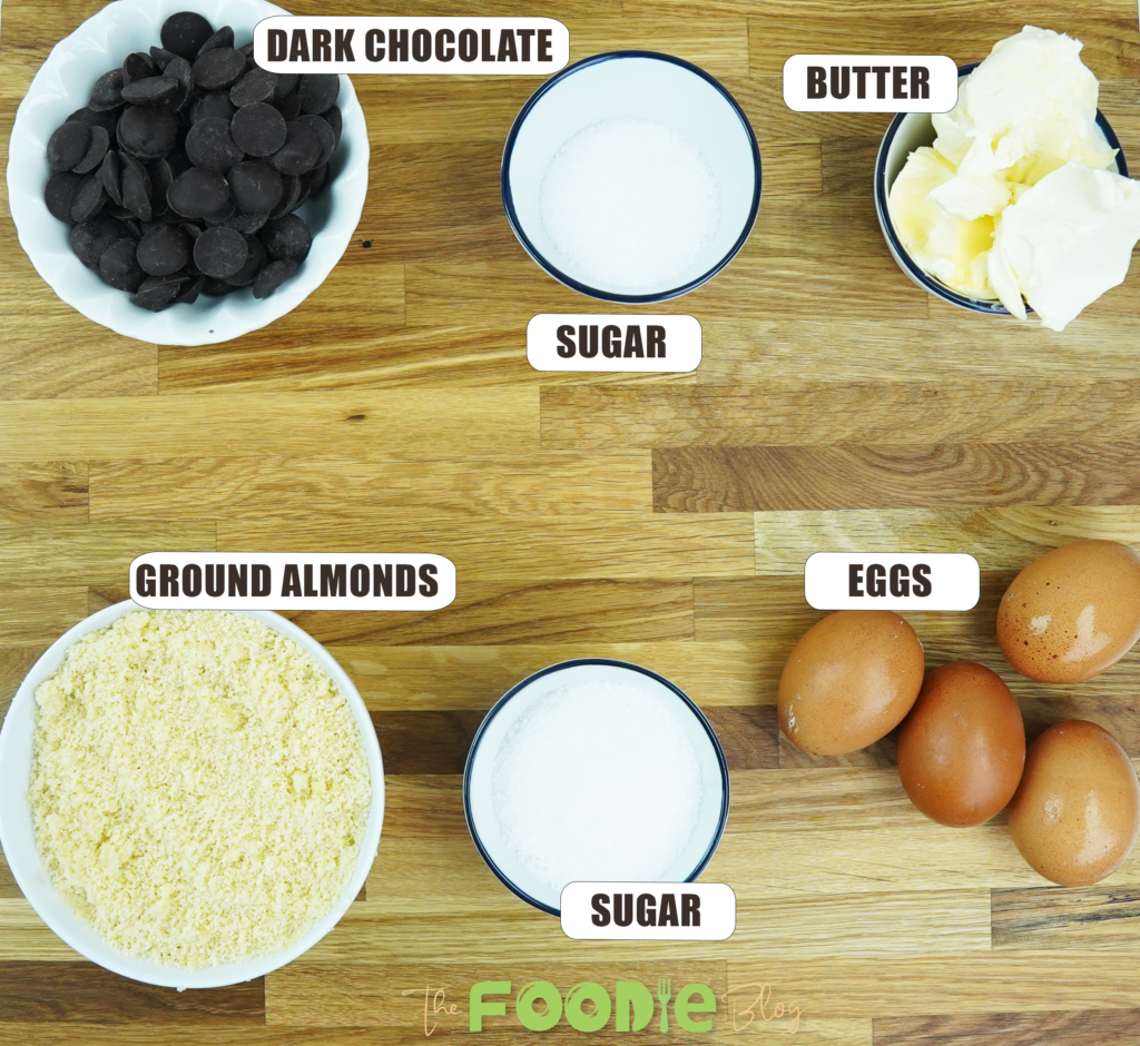 Dark chocolate, butter, sugar, eggs, and ground almonds arranged for the cake