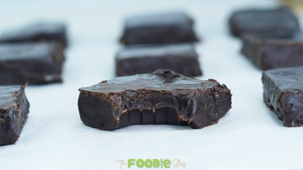 Several squares of 3-ingredient chocolate fudge arranged on parchment paper