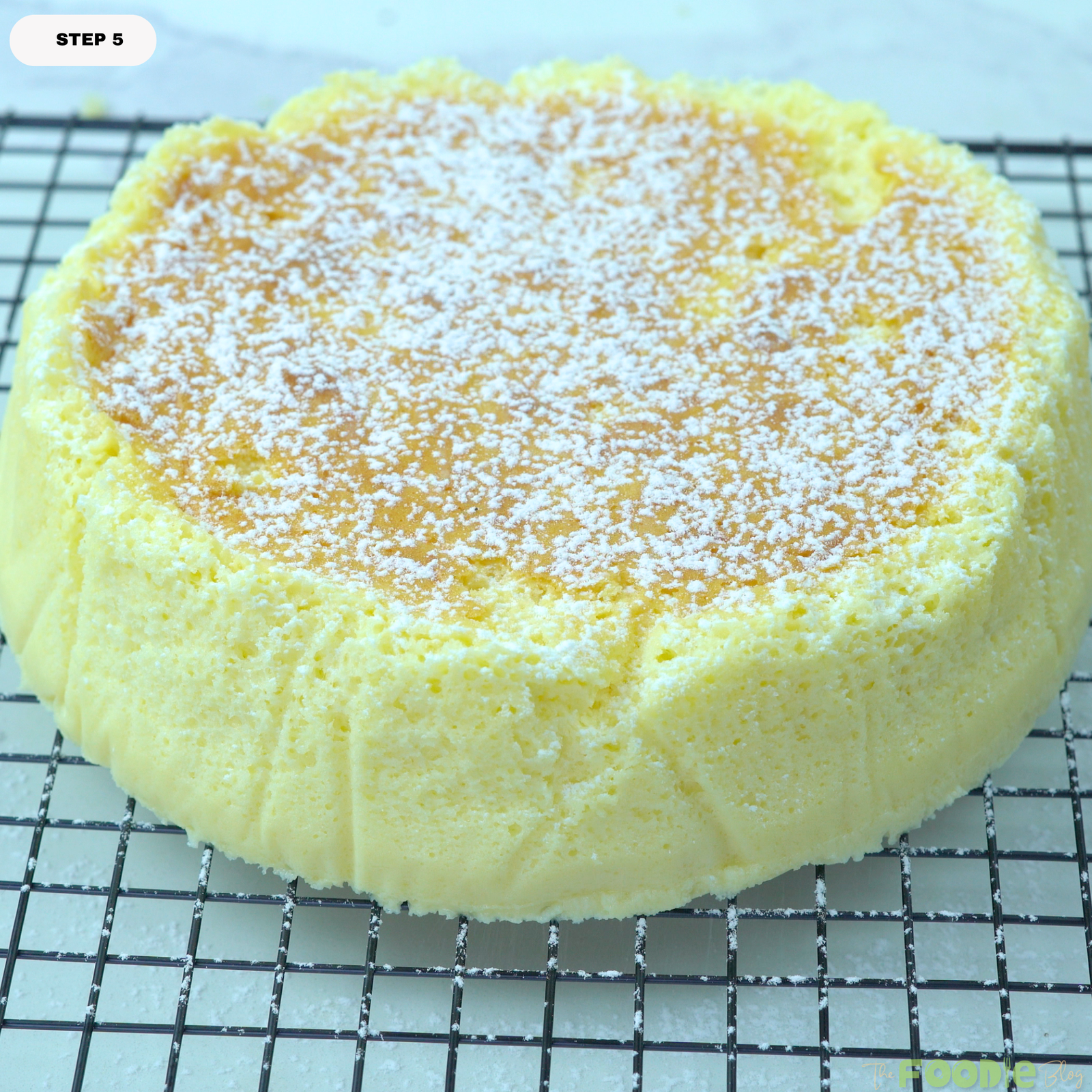 Baked Japanese cheesecake cooling on a rack and dusted with powdered sugar