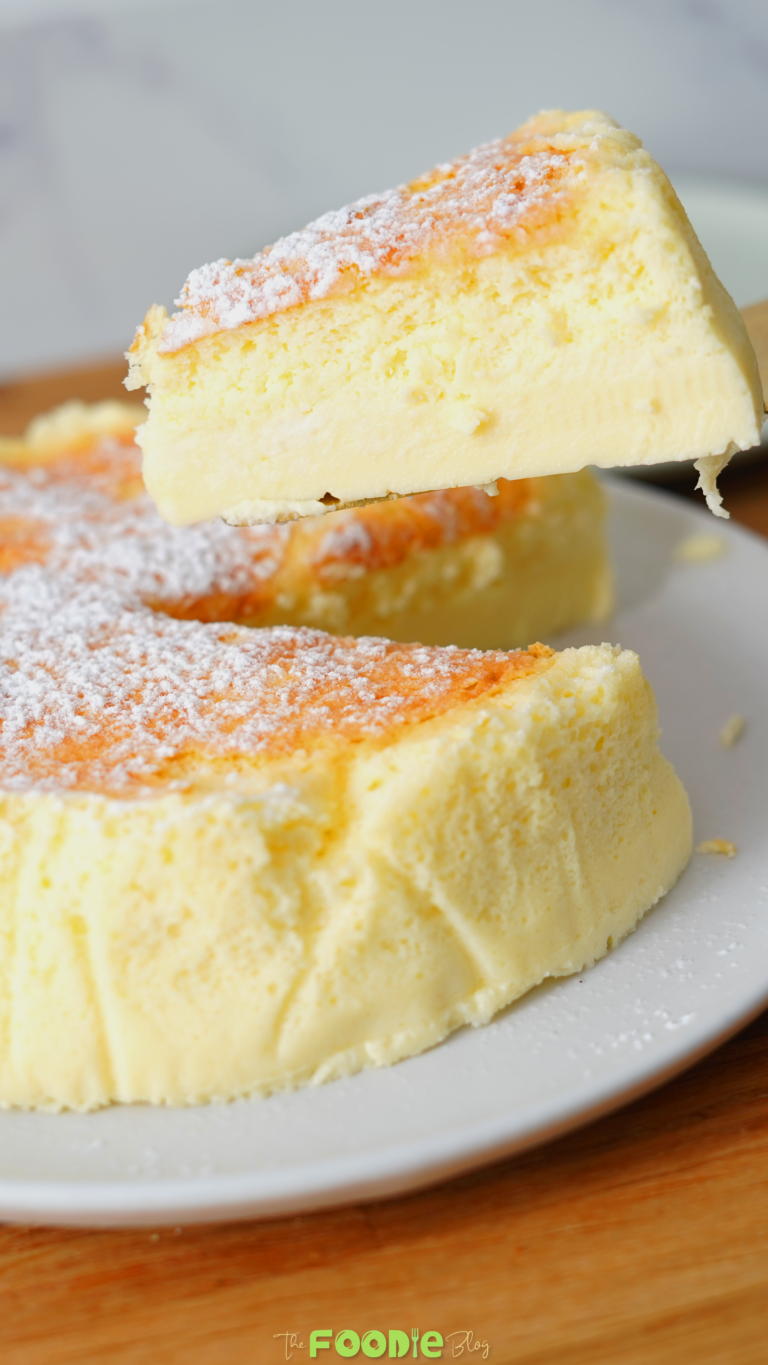 Close-up of a slice of Japanese cheesecake lifted from the cake showing the airy top and creamy center