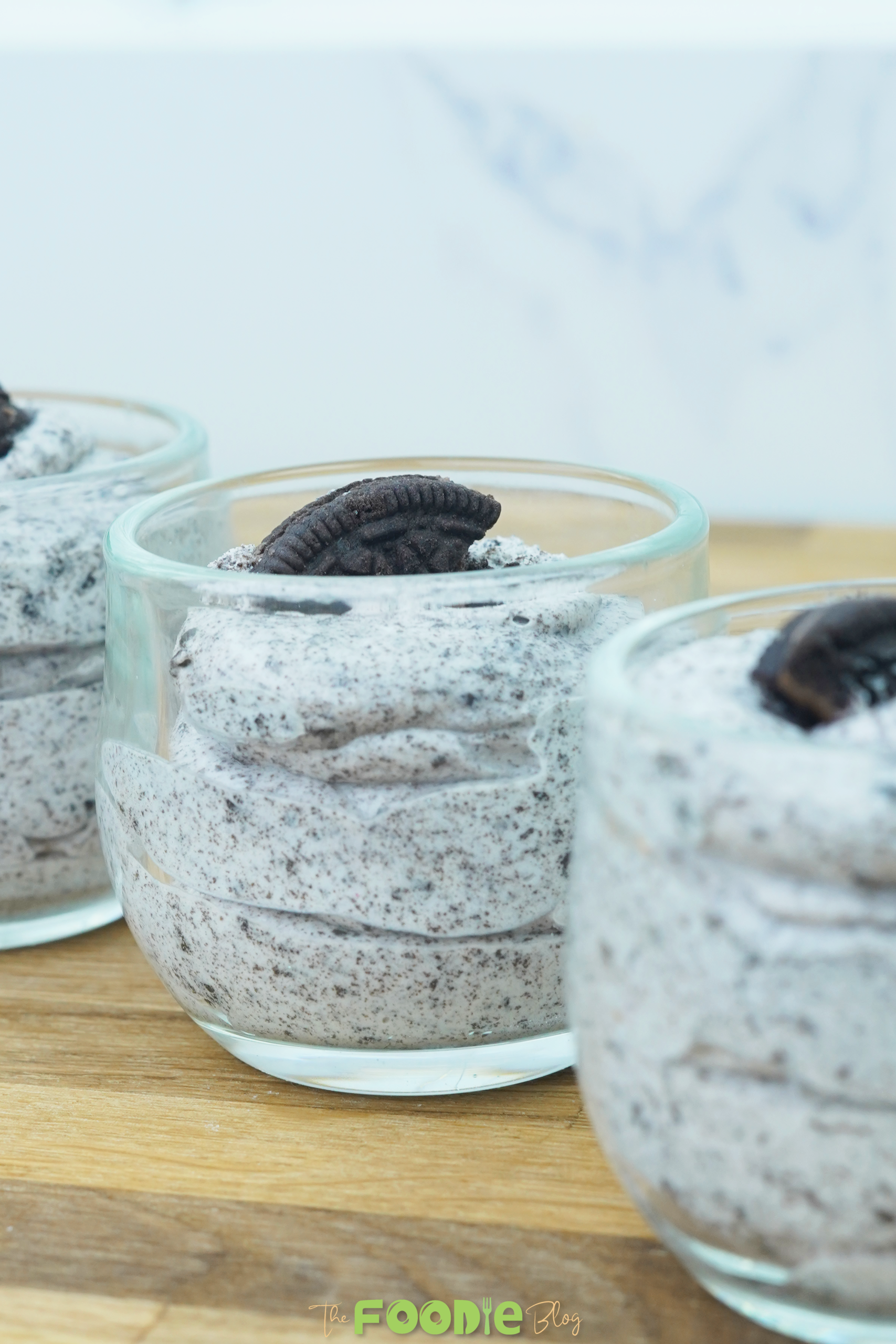 Small glass cups filled with Oreo mousse and topped with cookie pieces