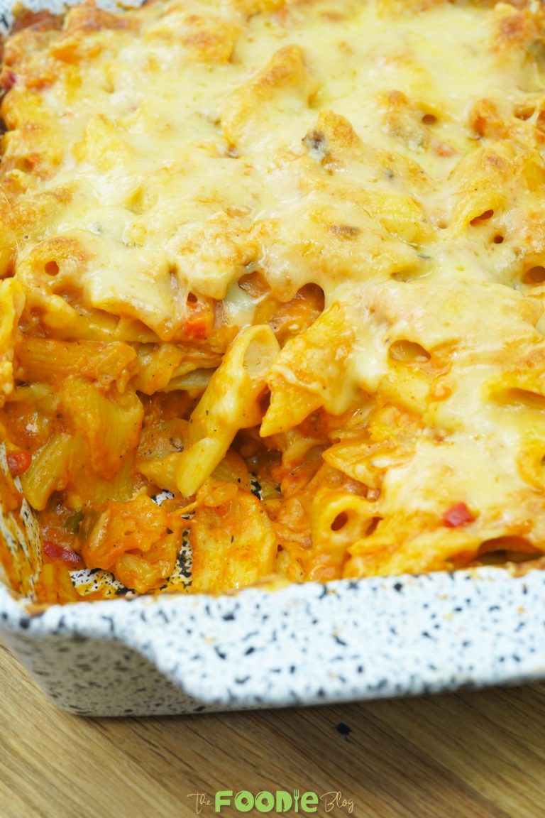 vertical close-up of baked chicken pasta casserole with melted cheese and penne