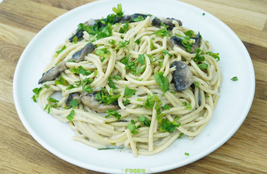 finished creamy mushroom pasta with mushrooms and chopped parsley in a white bowl
