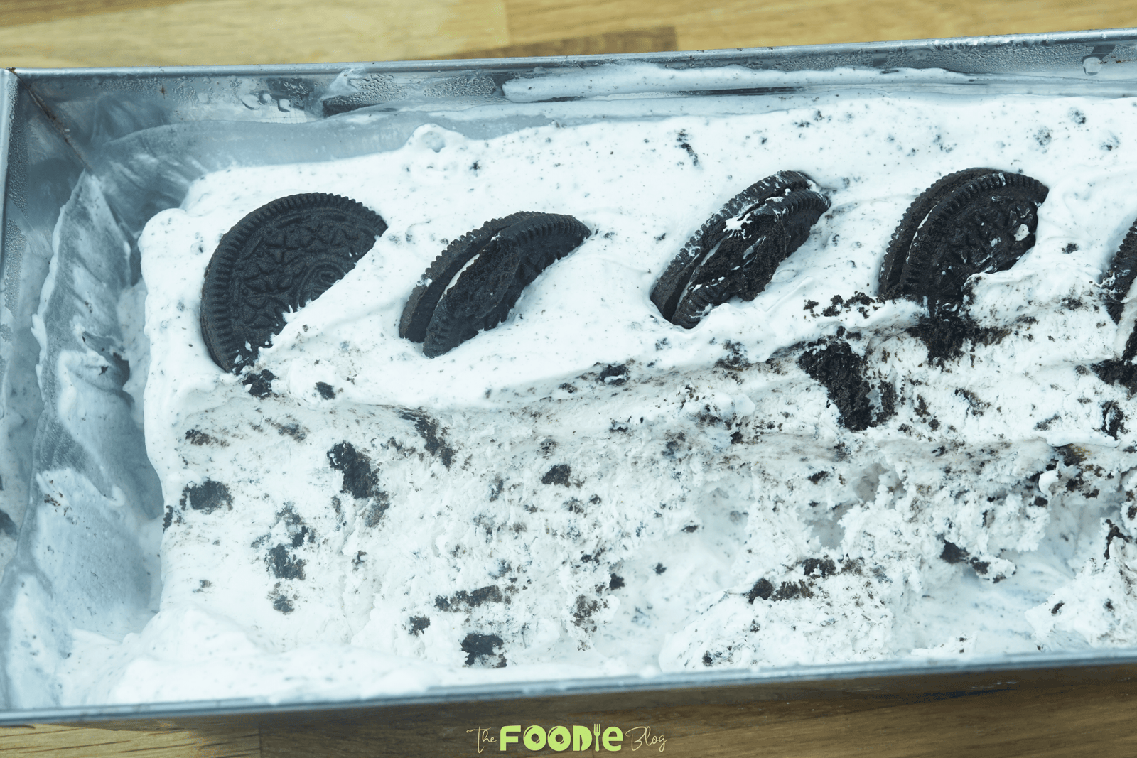No-churn Oreo ice cream in a loaf pan topped with Oreo cookie halves