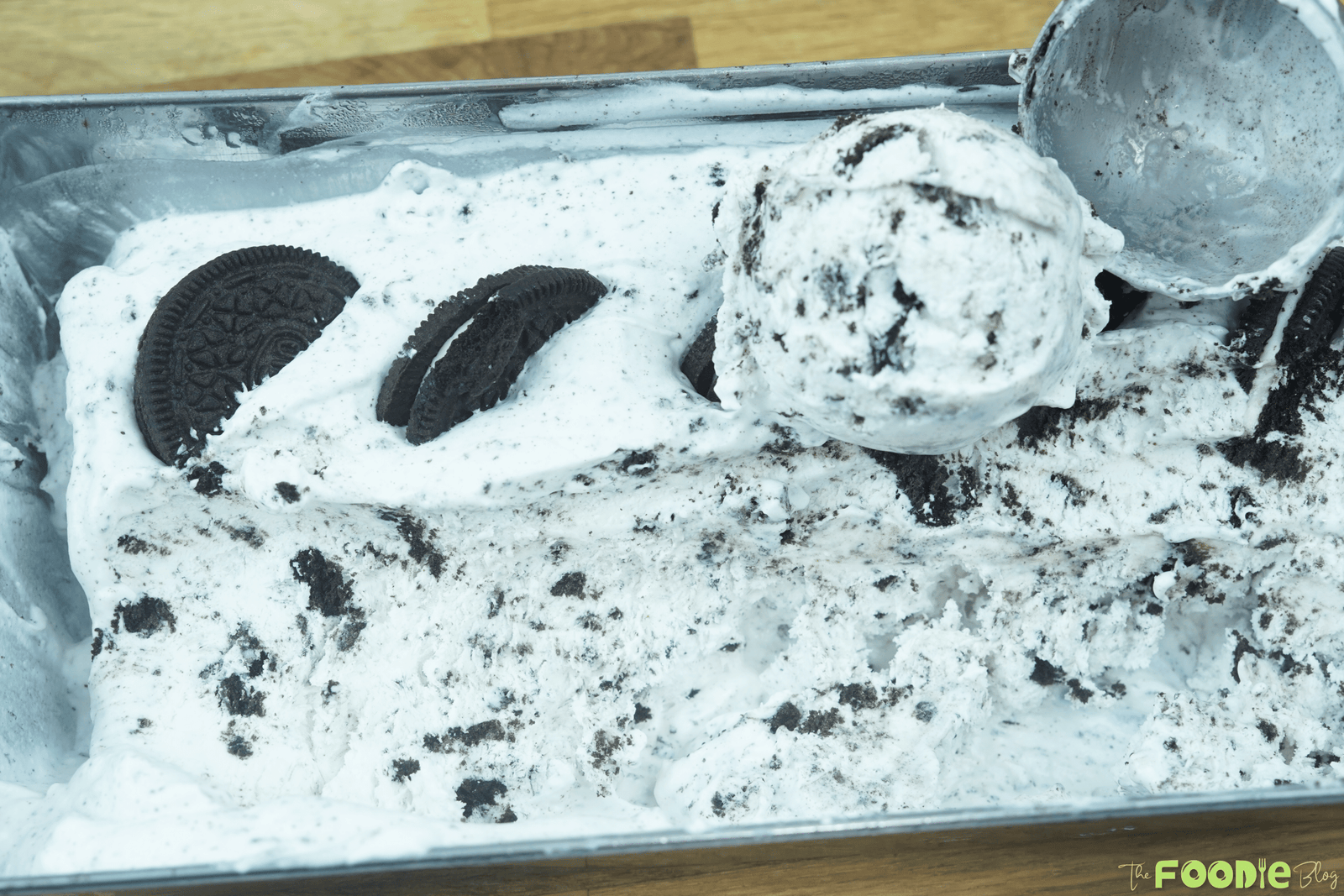 Scoop of easy homemade Oreo ice cream lifted from the loaf pan with cookie pieces throughout