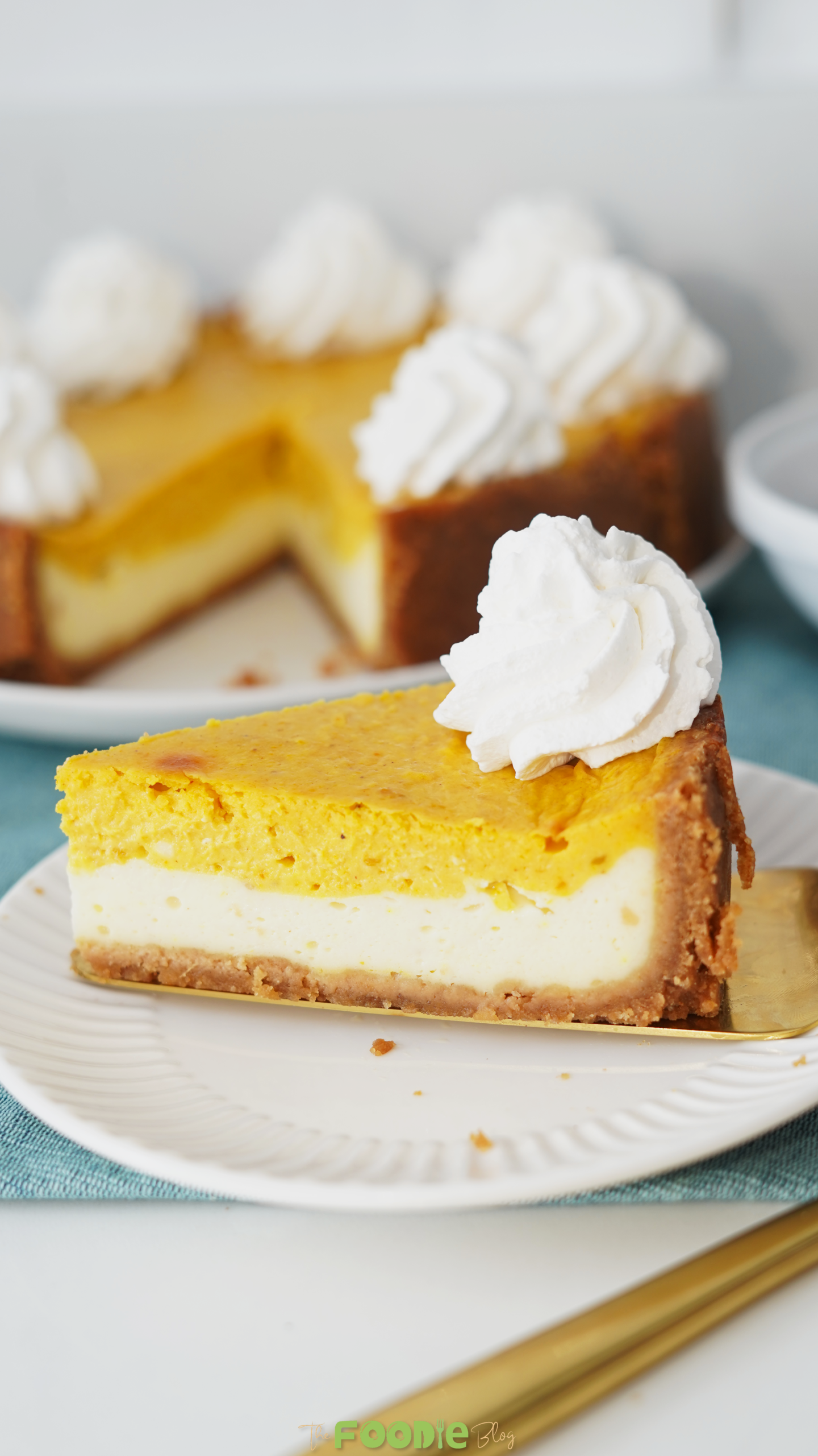 Easy pumpkin pie cheesecake sliced on a plate topped with whipped cream rosettes
