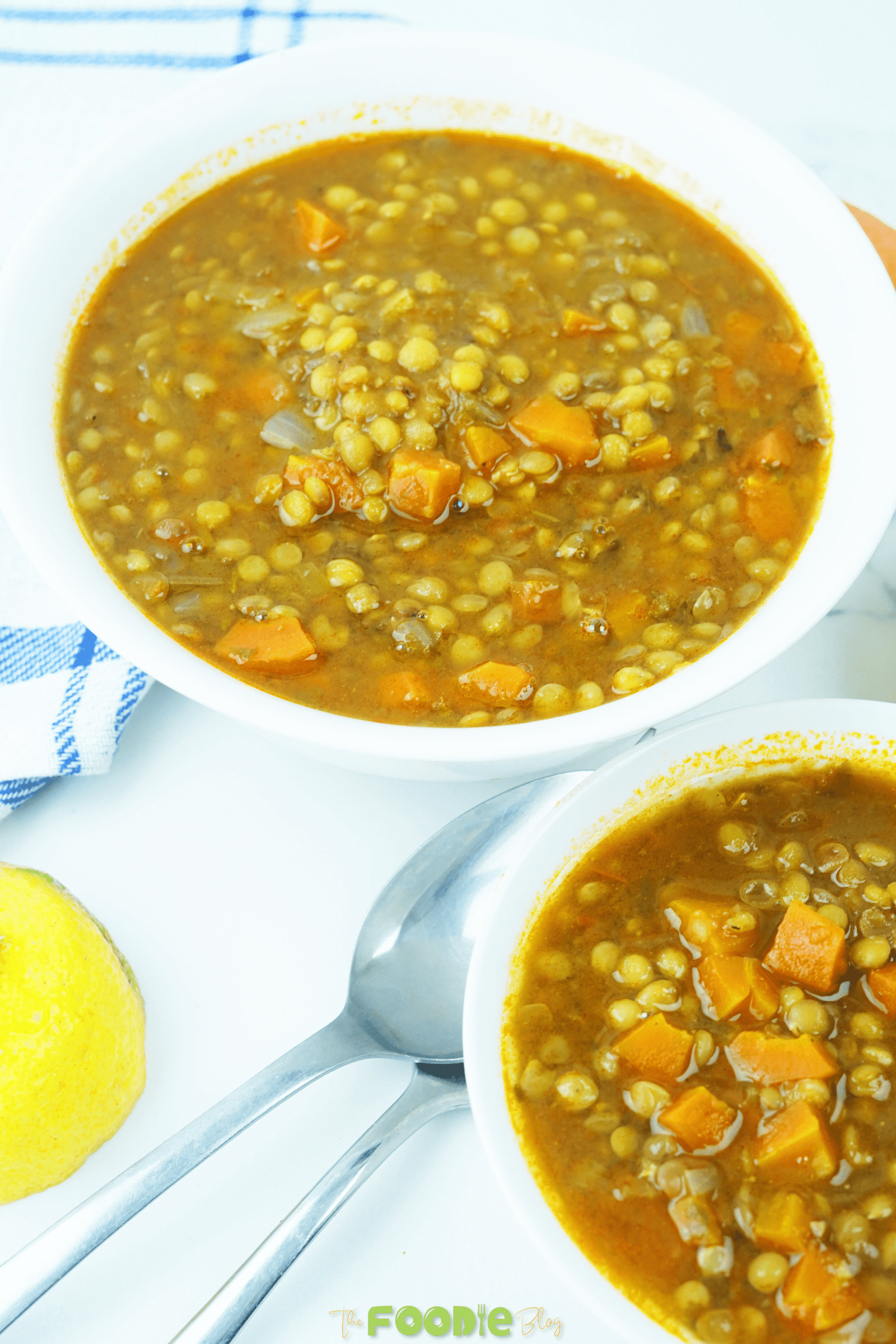Overhead close-up of lentil soup in a pot with carrots, onions, and herbs simmering together