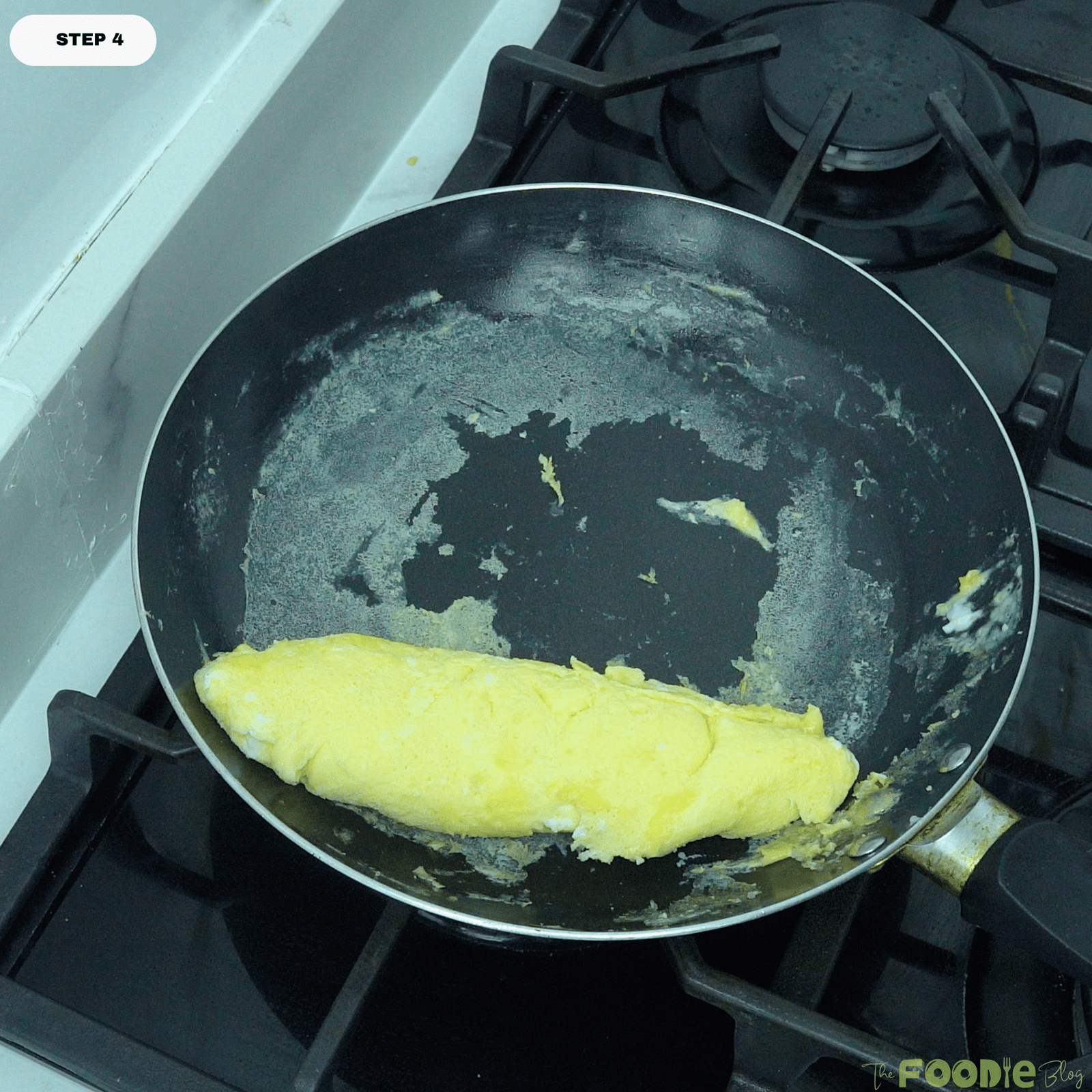 Finished French omelette sitting in the skillet after being shaped and cooked