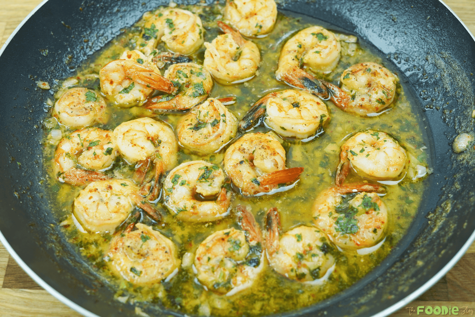 One-pan shrimp in garlic butter white wine sauce with parsley in a black skillet