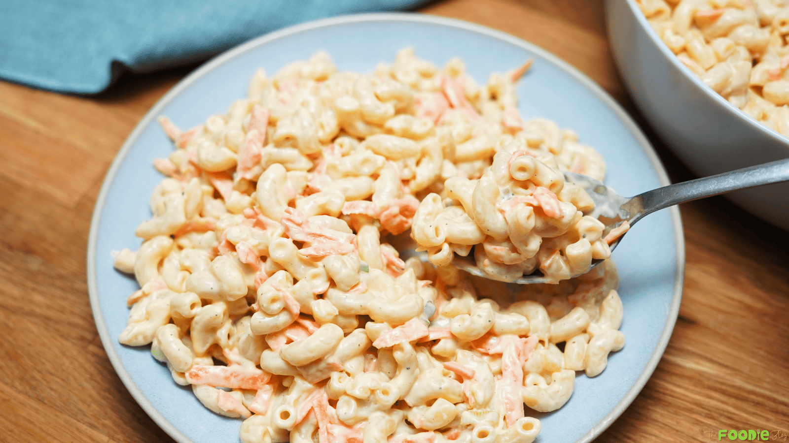 Hawaiian macaroni salad served on a plate with a fork lifting a bite from the creamy pasta salad