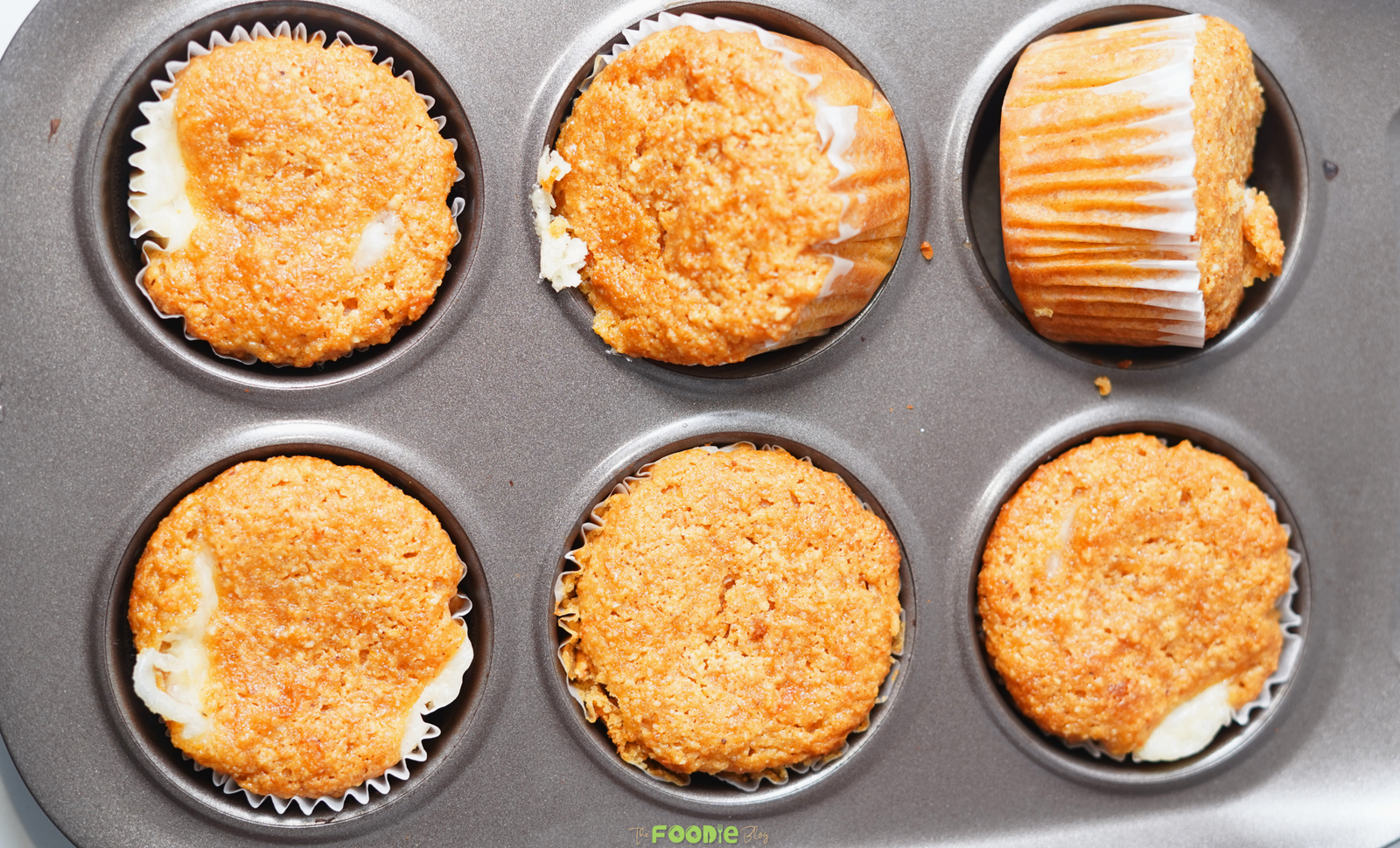 Freshly baked keto pumpkin muffins with cream cheese centers in a muffin pan