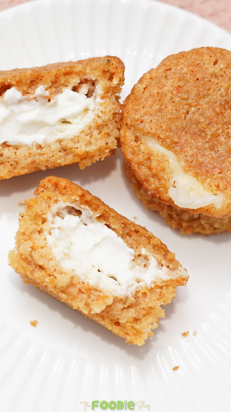 Keto pumpkin muffin cut open to show the creamy cream cheese filling inside