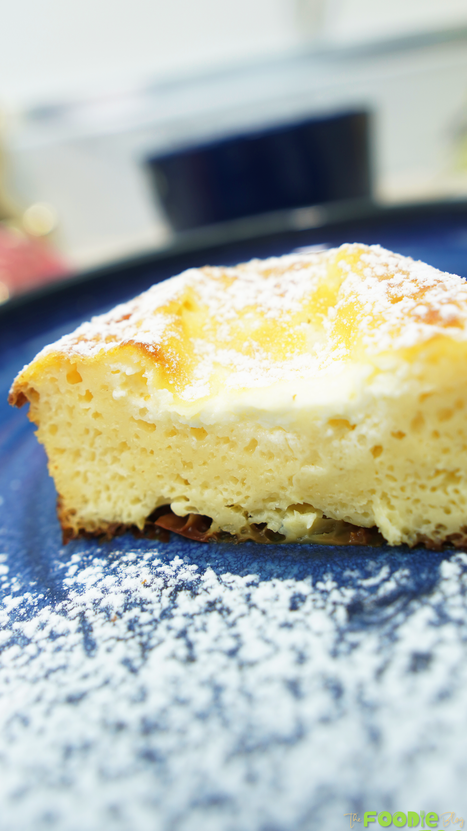 Close-up of a slice showing the airy, creamy interior on a blue plate
