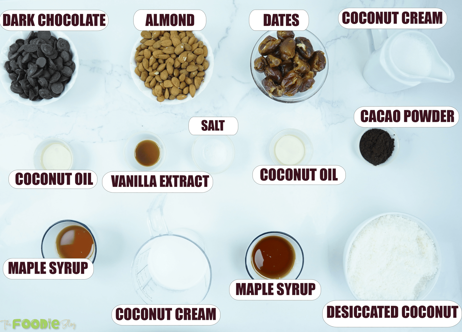 Ingredients for no-bake vegan bounty tart including dark chocolate, almonds, dates, coconut cream, cacao powder, coconut oil, maple syrup, vanilla extract, salt, and desiccated coconut