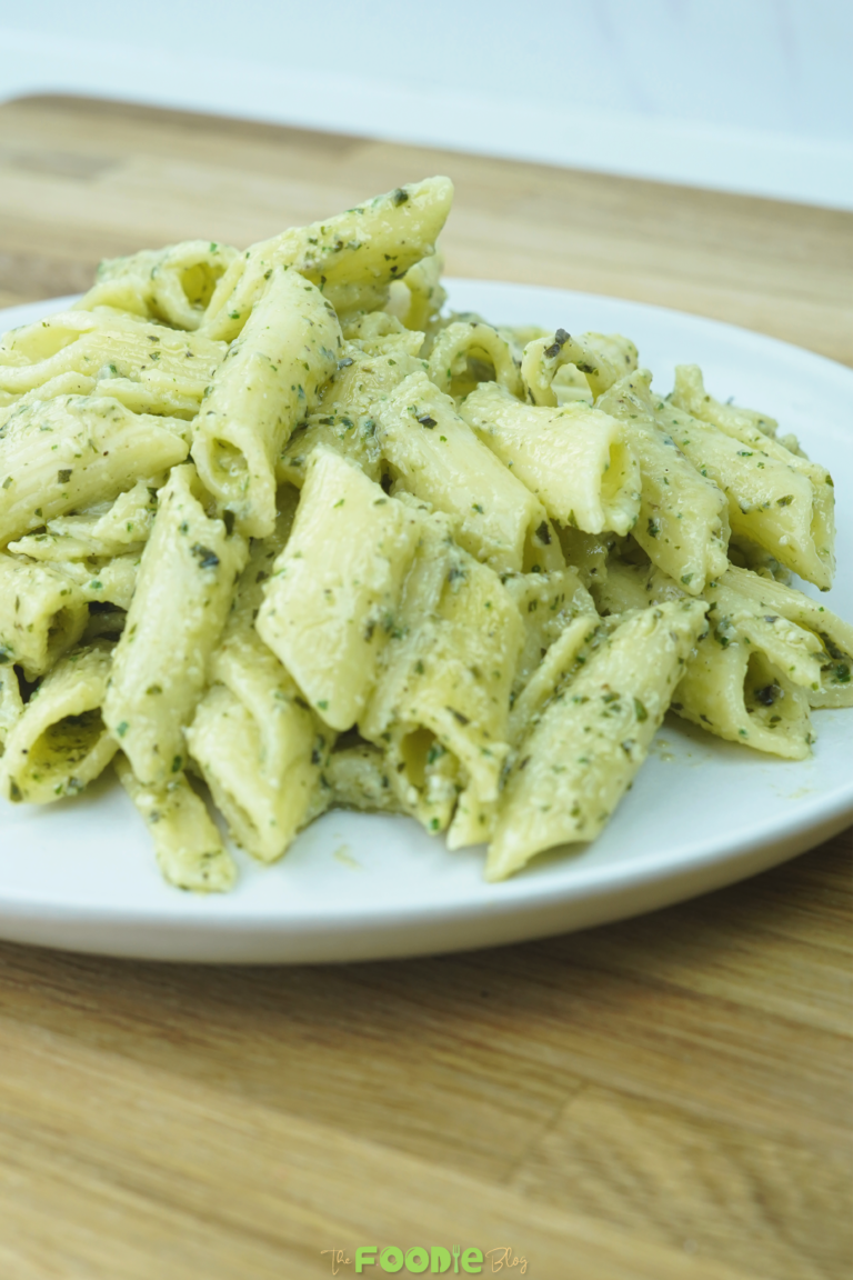 close-up side view of pesto pasta on a white plate