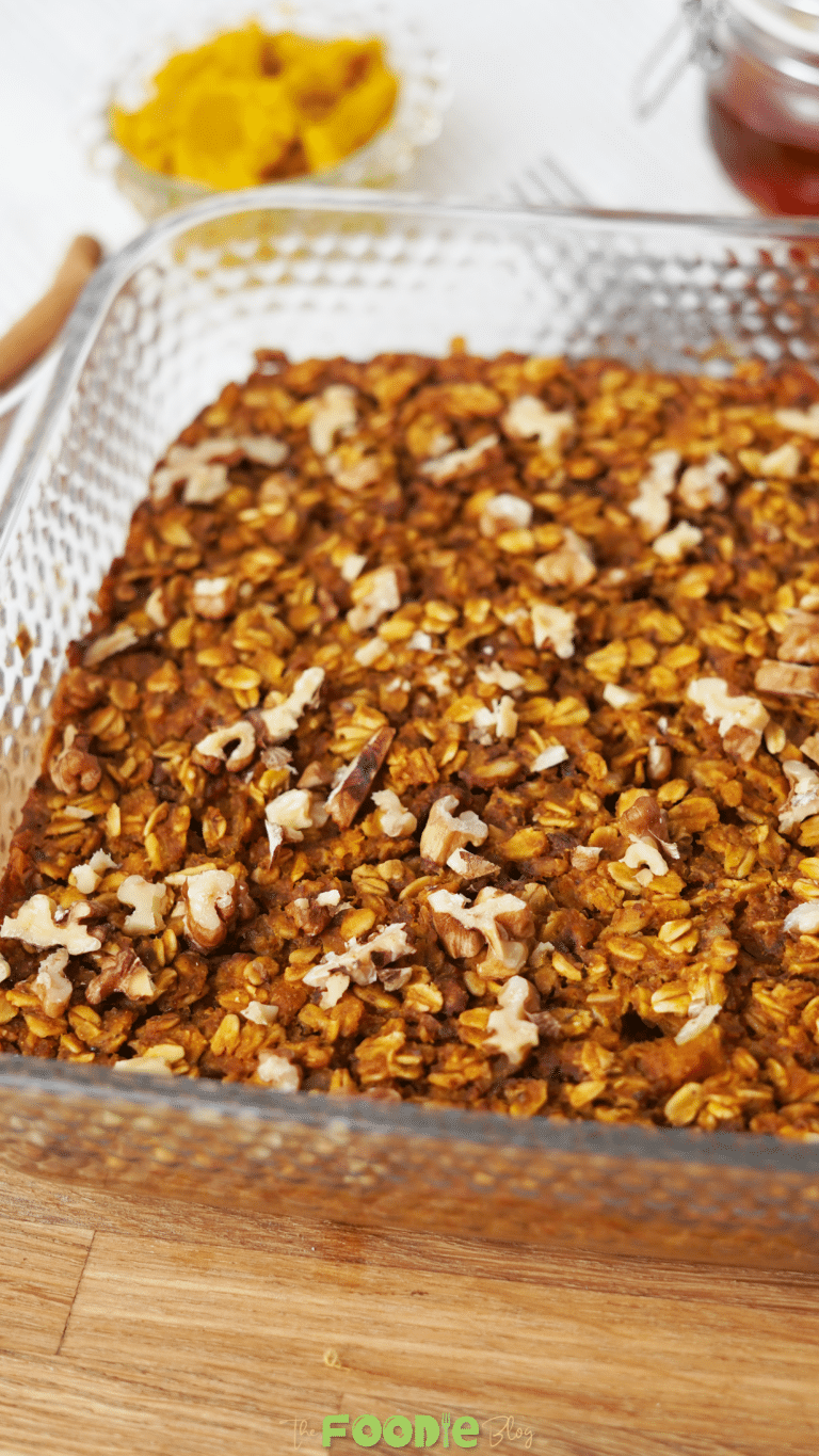 Pumpkin baked oatmeal in a glass baking dish topped with chopped nuts