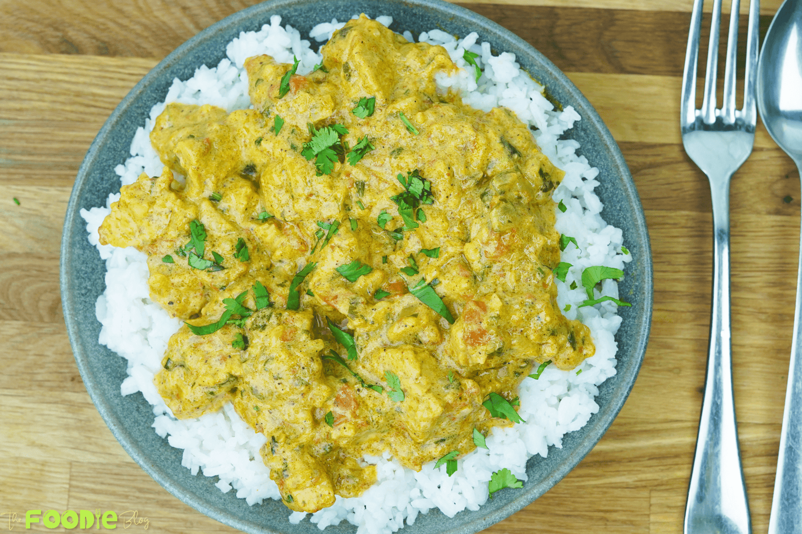 Top view of quick and easy chicken curry served over white rice and garnished with chopped cilantro
