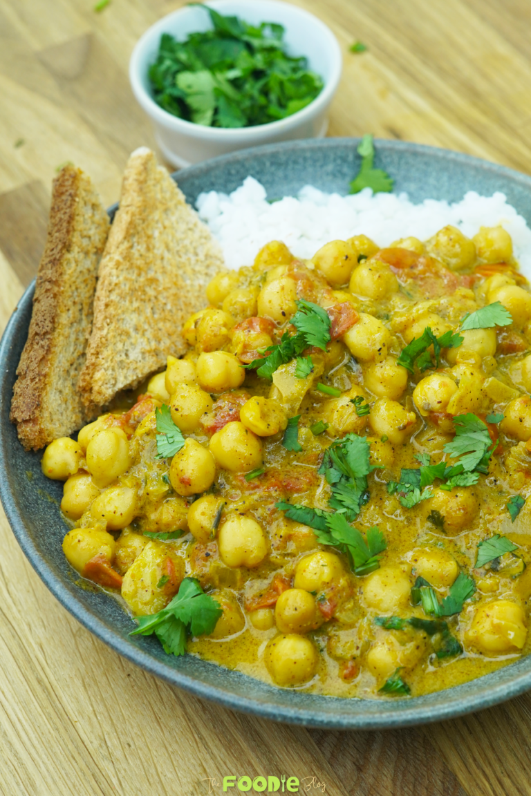 finished chickpea curry in a bowl with rice and fresh cilantro