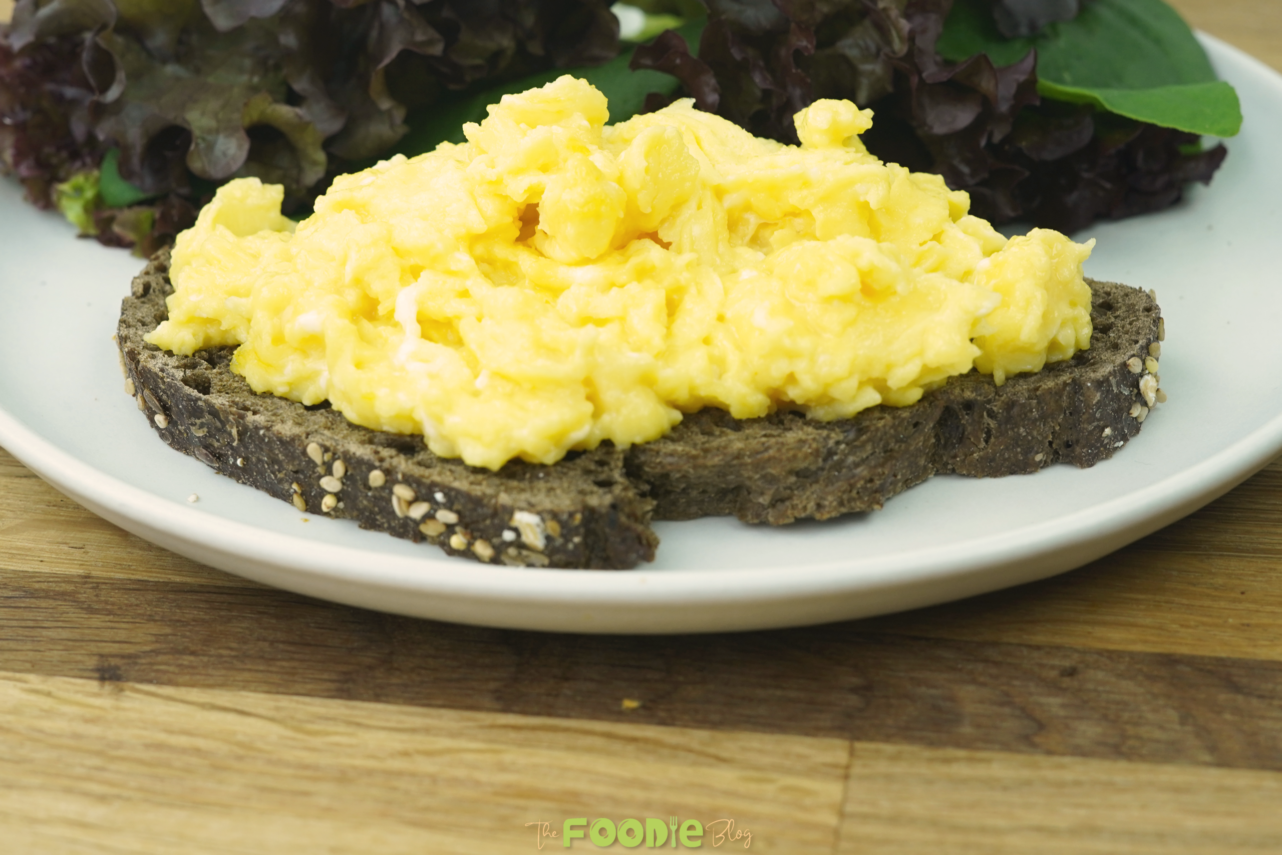 close-up of fluffy scrambled eggs served on dark toast