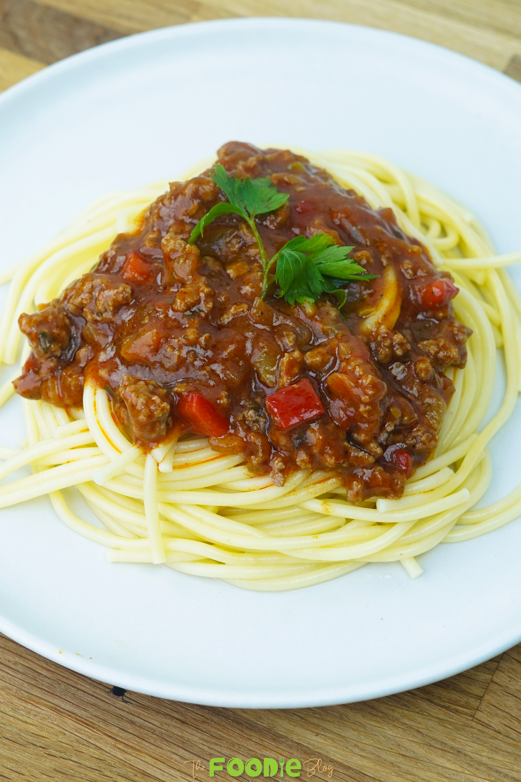 serving view of spaghetti with meat sauce on a white plate