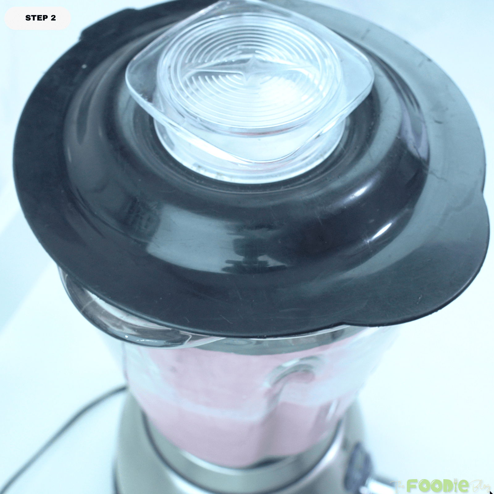 Strawberry banana smoothie blending in a blender until smooth and creamy