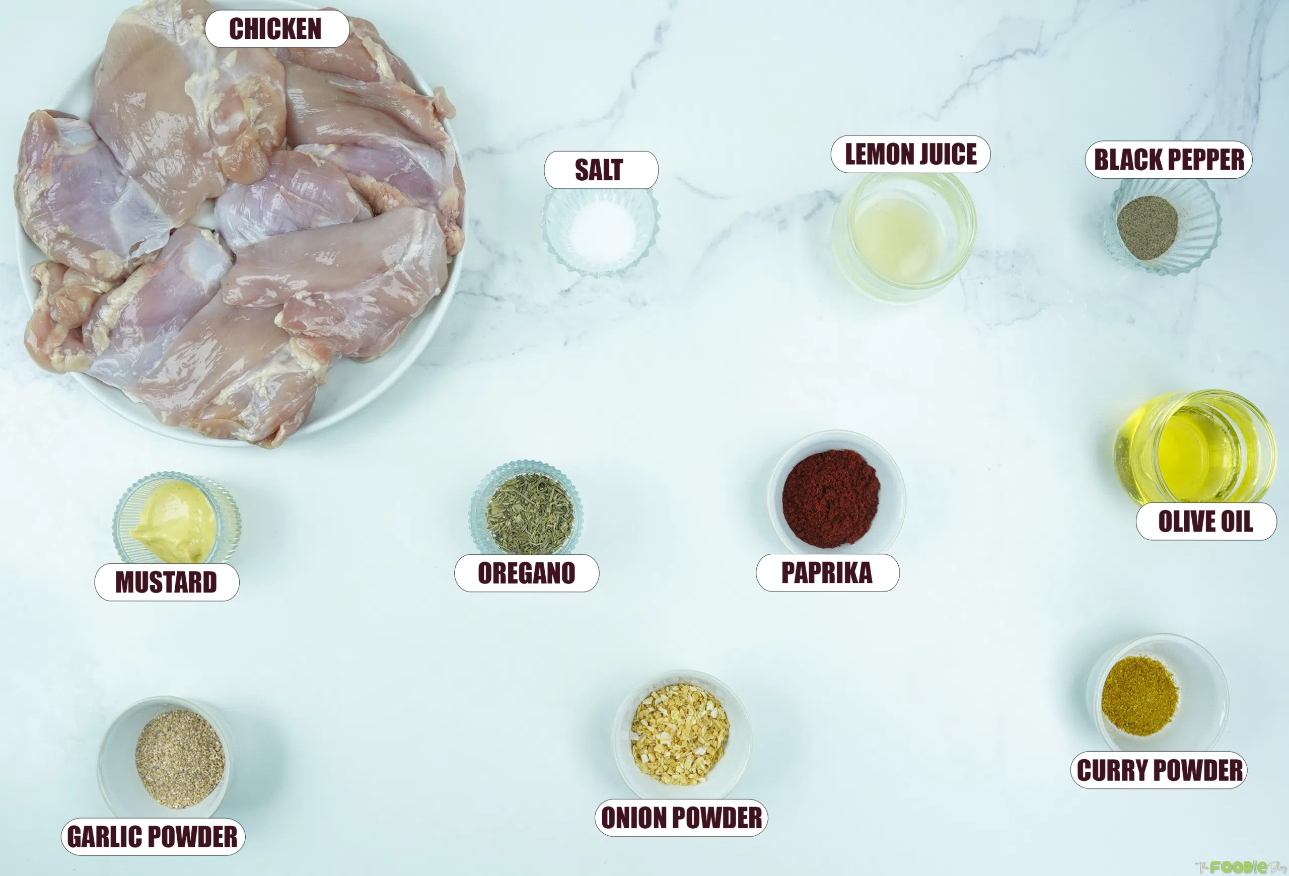 Ingredients for chicken skewers including chicken thighs, olive oil, lemon juice, mustard, paprika, oregano, garlic powder, onion powder, curry powder, salt, and black pepper.