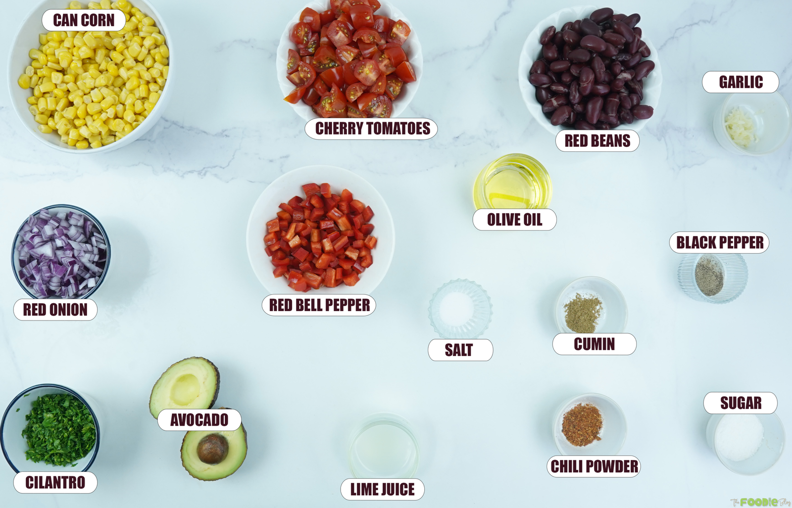 Ingredients for cowboy bean salad including corn, cherry tomatoes, red beans, red onion, avocado, cilantro, red bell pepper, lime juice, garlic, olive oil, cumin, chili powder, salt, black pepper, and sugar.