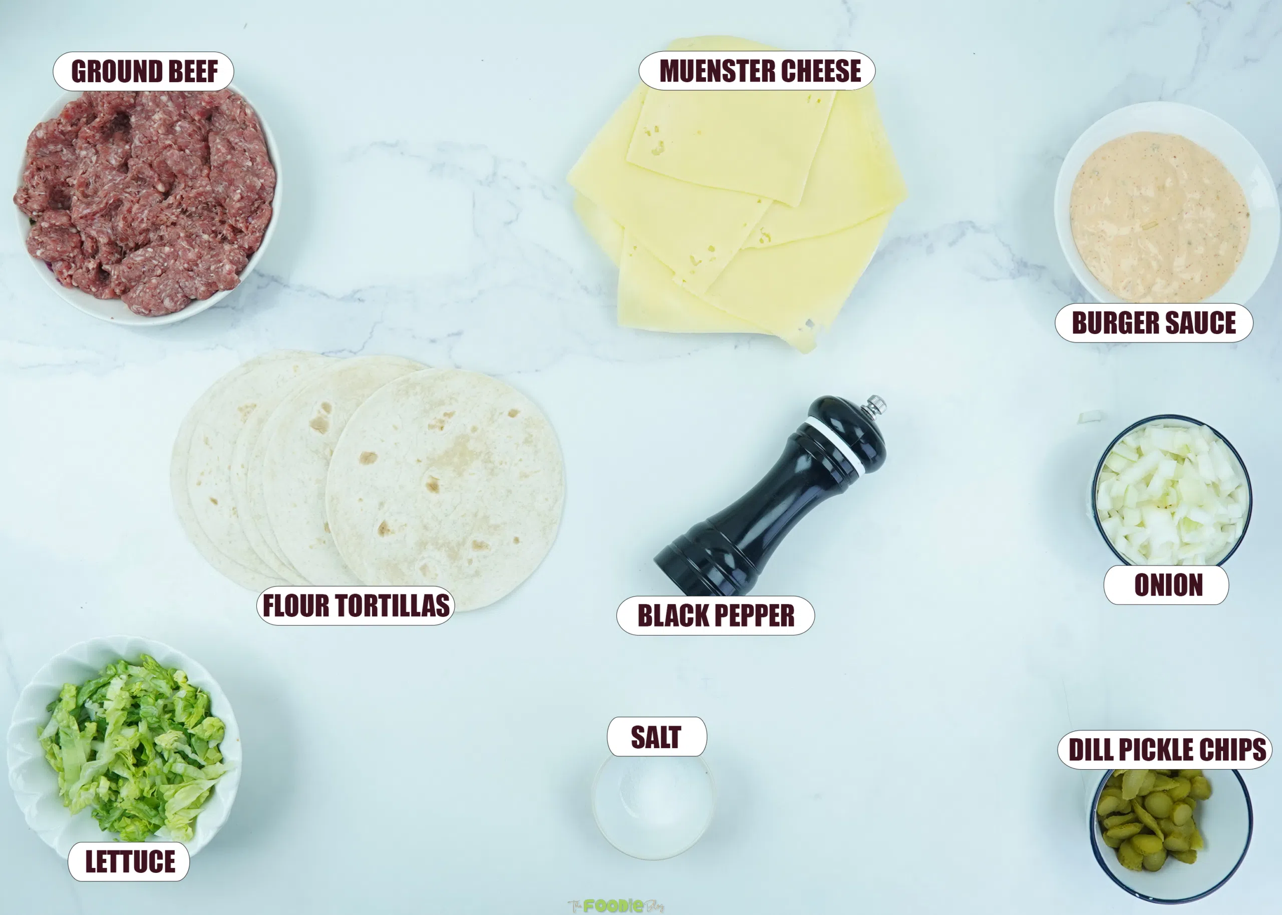 Ingredients for smash burger tacos including ground beef, flour tortillas, muenster cheese, burger sauce, lettuce, onion, pickles, salt, and pepper.