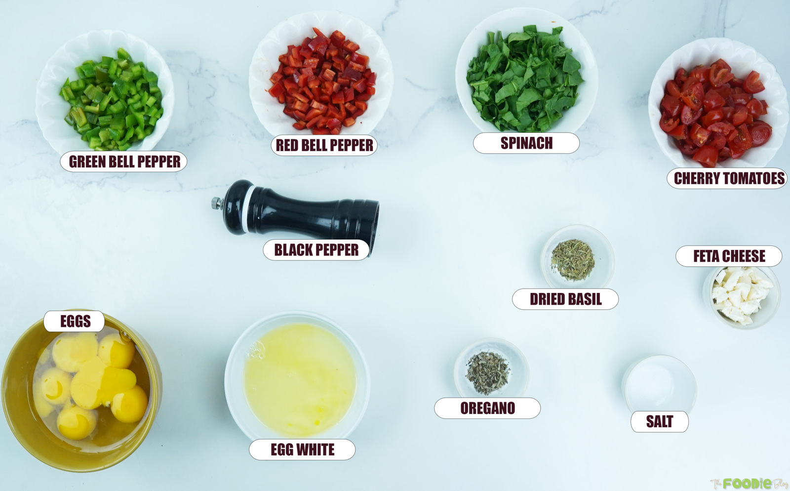 Ingredients for egg muffins including eggs, egg whites, spinach, bell peppers, cherry tomatoes, feta, herbs, salt, and pepper.