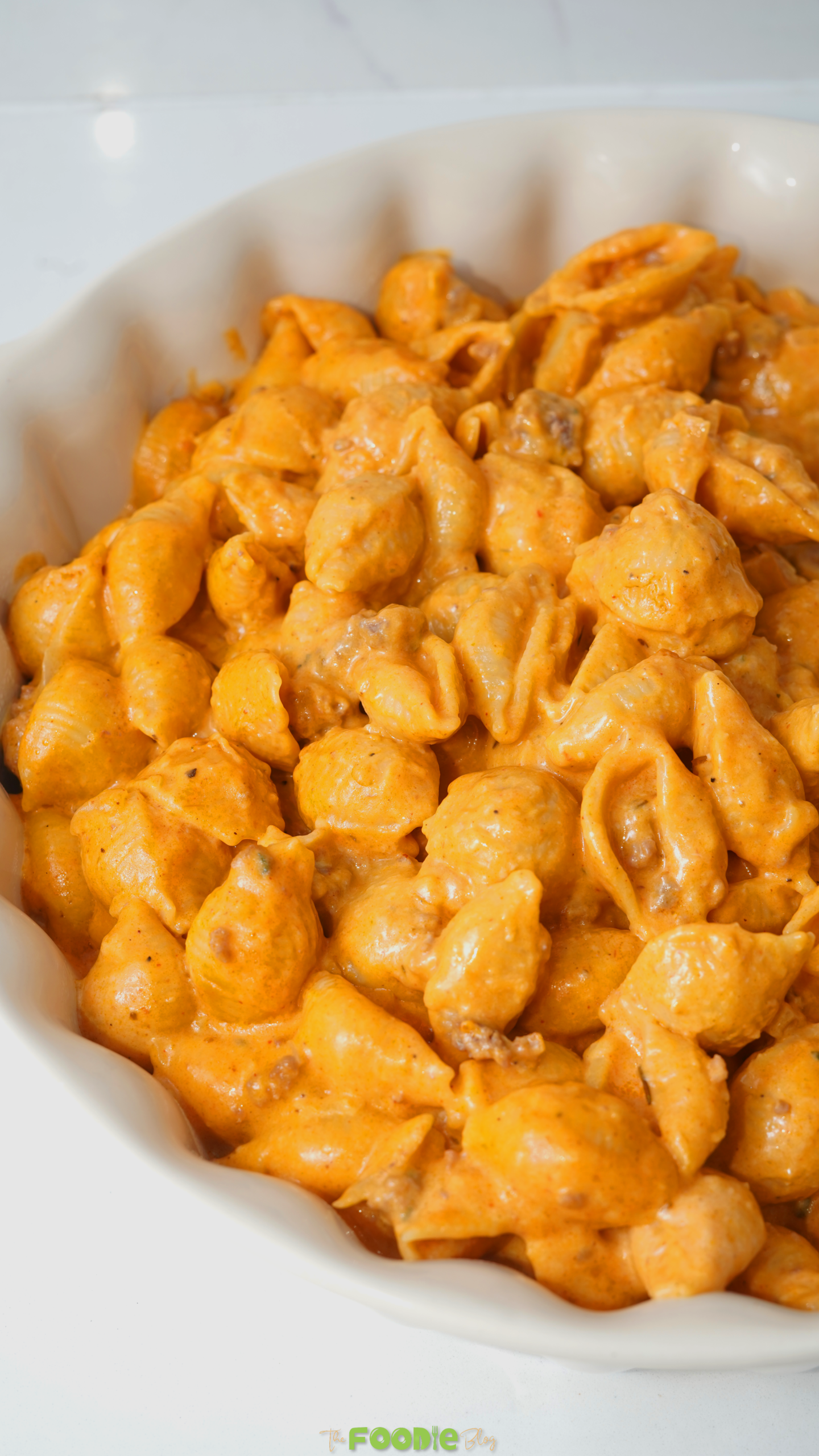 Creamy homemade hamburger helper served in a white baking dish with pasta shells coated in a cheesy tomato sauce.