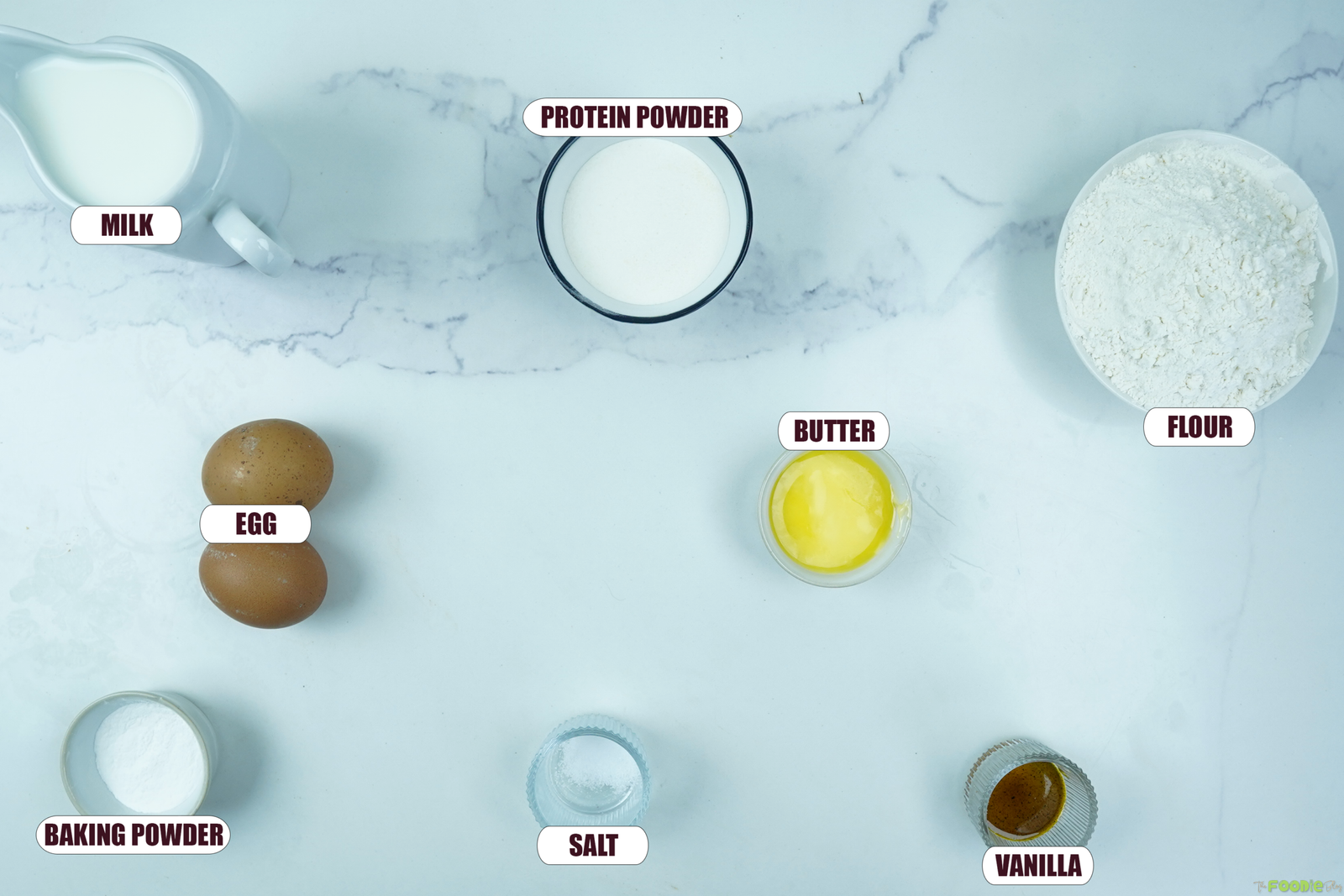 Ingredients for protein pancakes including flour, vanilla protein powder, milk, eggs, butter, baking powder, salt, and vanilla.