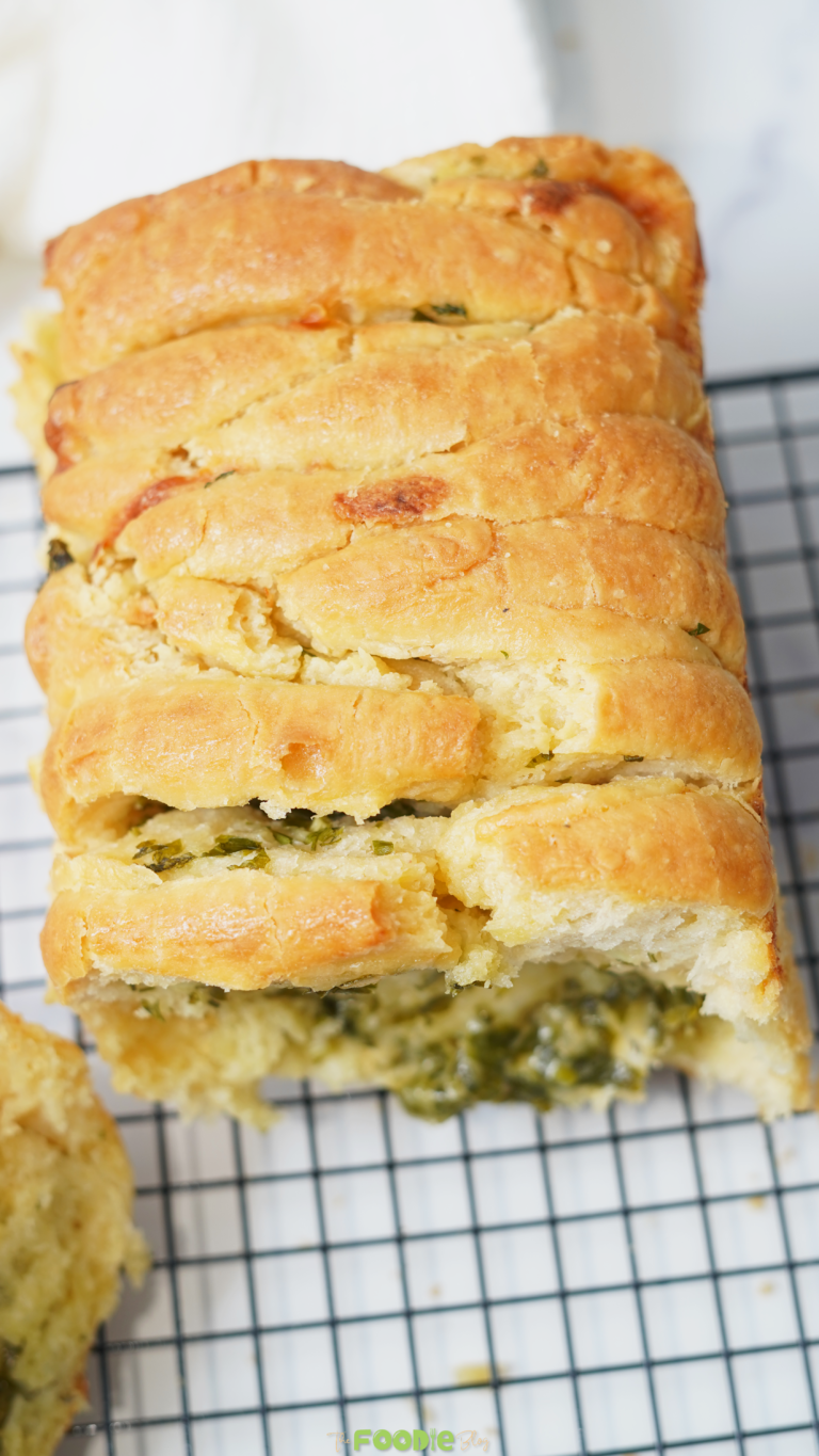 Golden baked sourdough pull apart bread resting on a cooling rack.