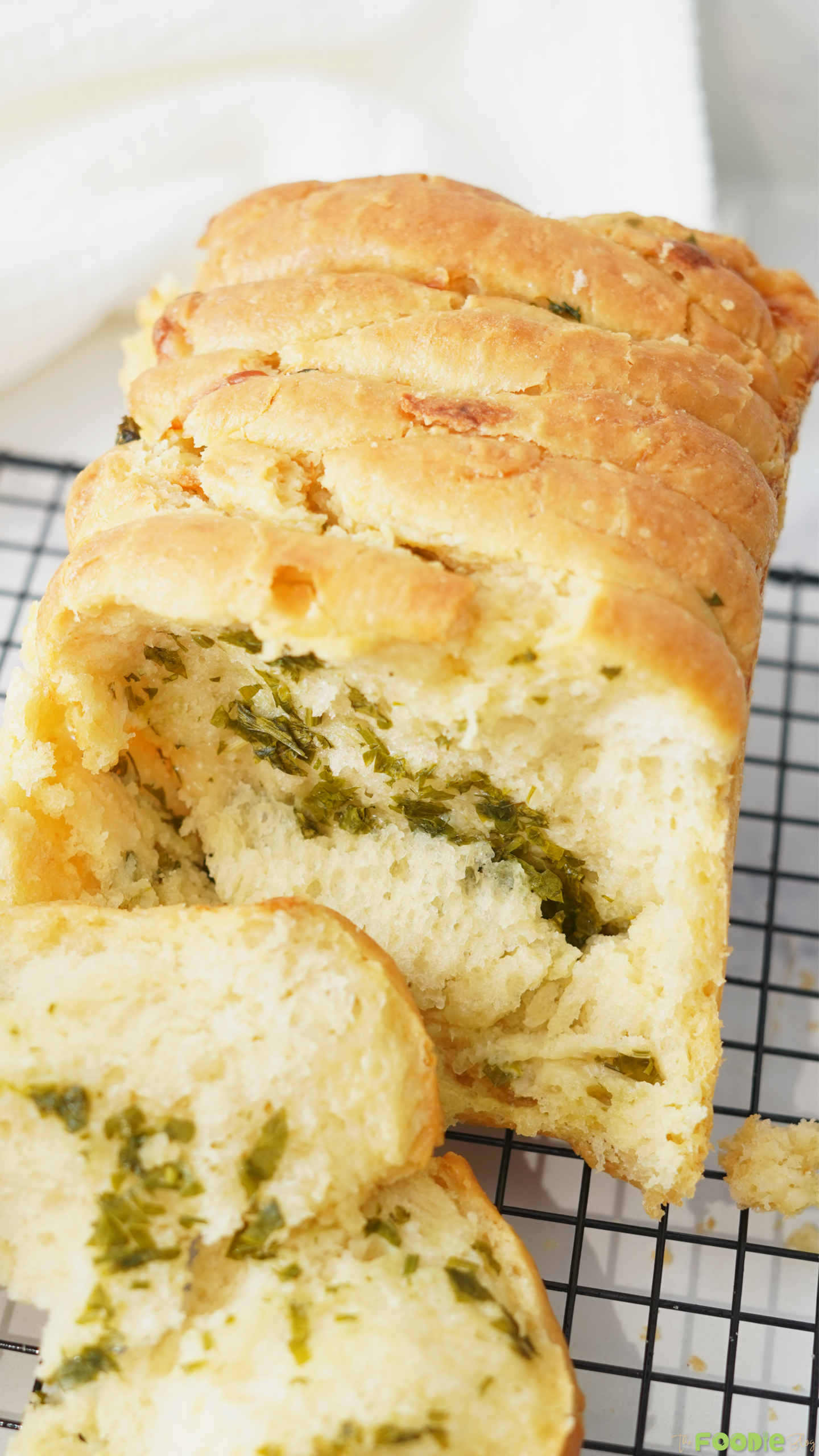 Sliced sourdough pull apart bread showing soft layers with garlic herb filling.