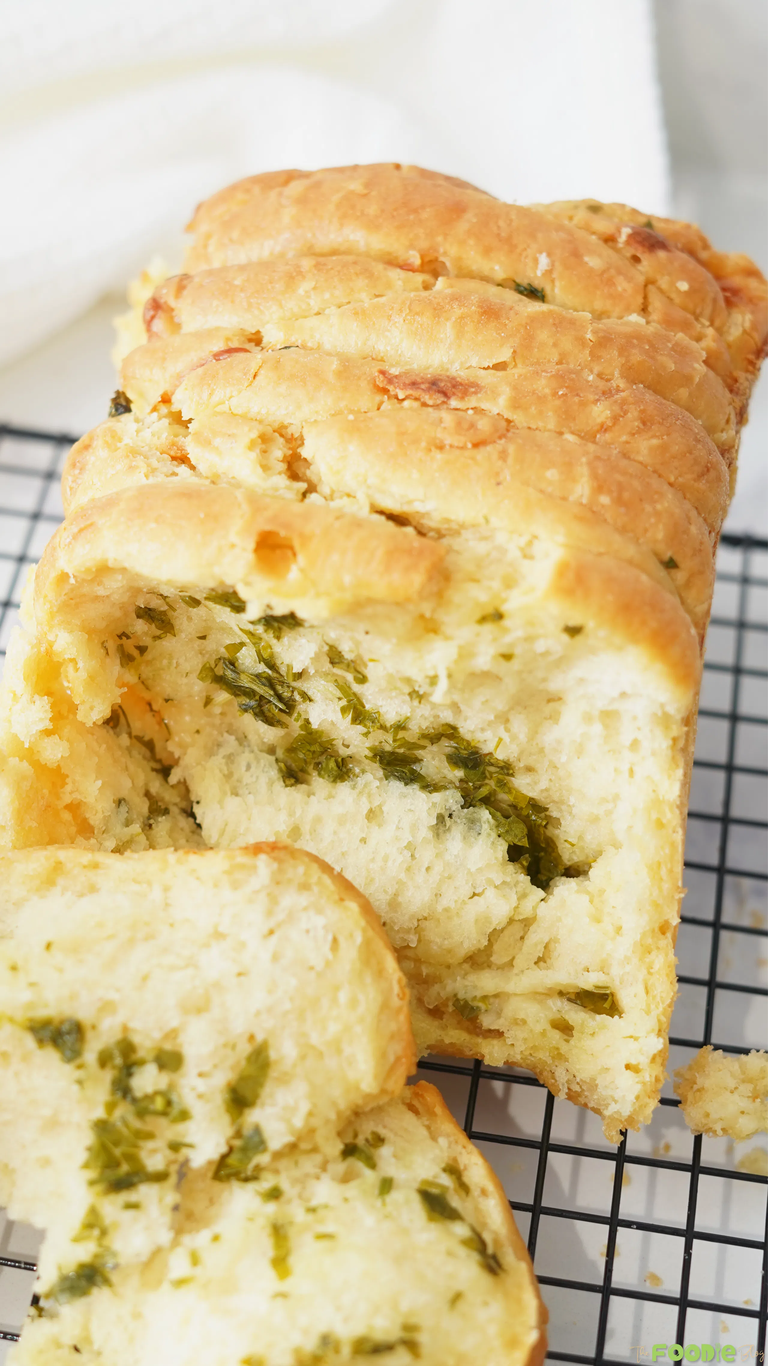 Sliced sourdough pull apart bread showing soft layers with garlic herb filling.