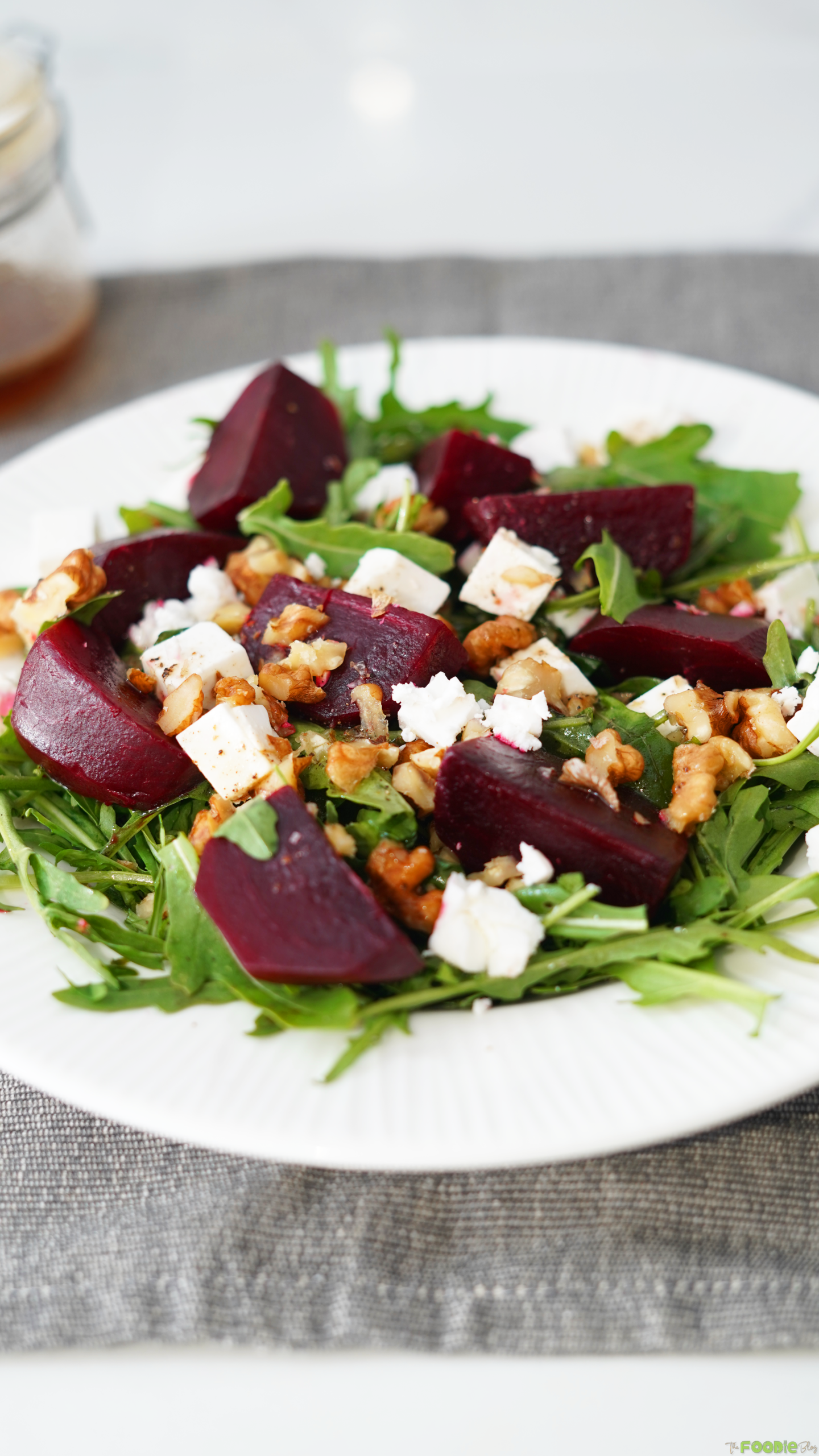 Close-up of beetroot salad with arugula, feta cheese, and walnuts.