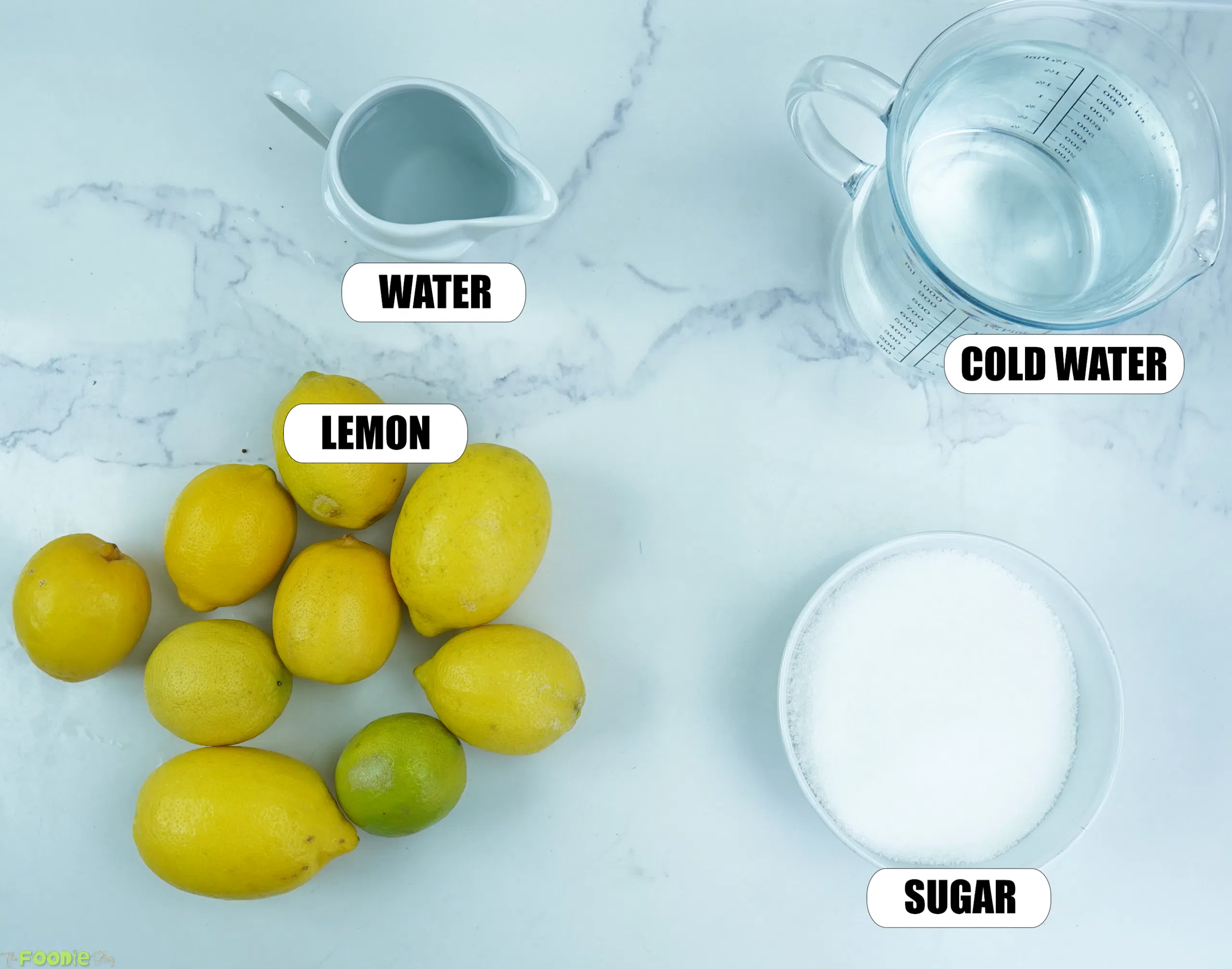 Ingredients for homemade lemonade with fresh lemons, sugar, water, and cold water on a white marble background.