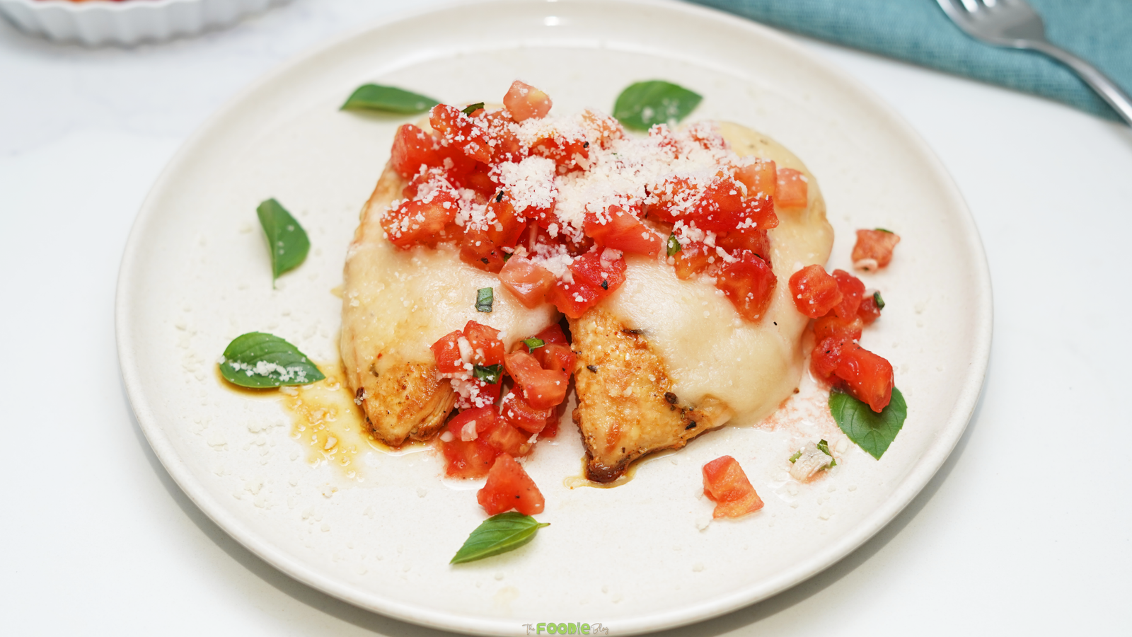 Chicken breasts topped with melted mozzarella, chopped tomatoes, basil, and Parmesan cheese.