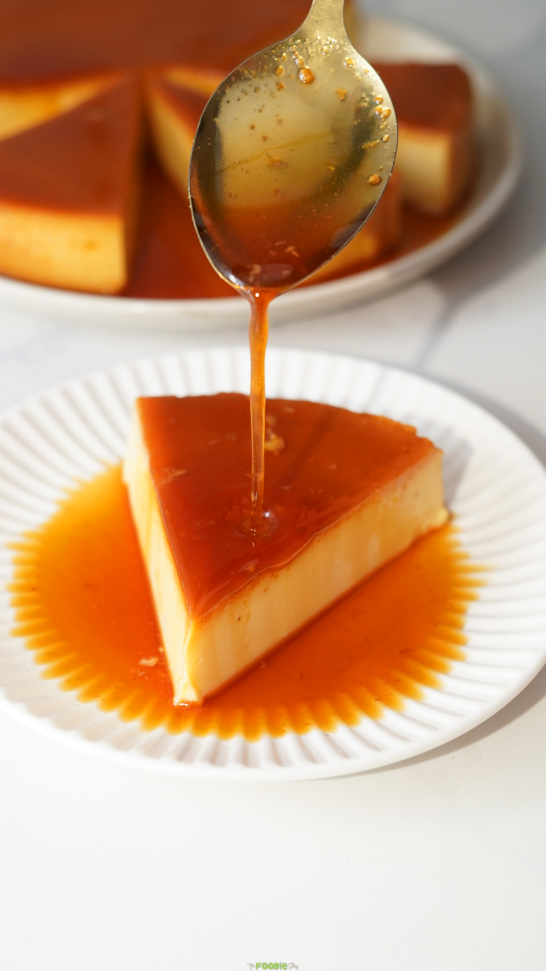 Caramel sauce dripping from a spoon over a slice of creamy custard.