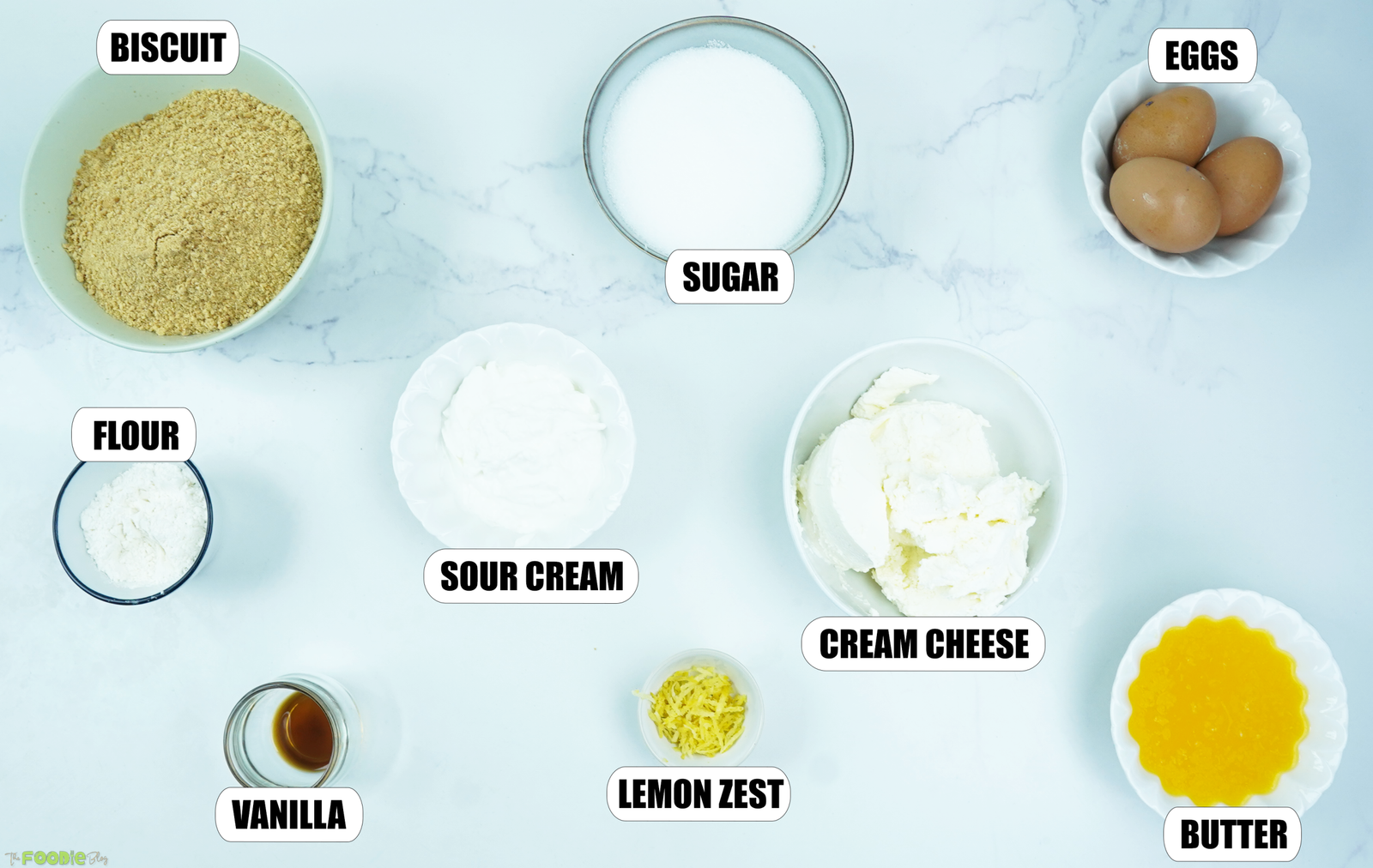 Biscuit crumbs, cream cheese, sour cream, eggs, sugar, flour, lemon zest, vanilla, and melted butter for cheesecake.