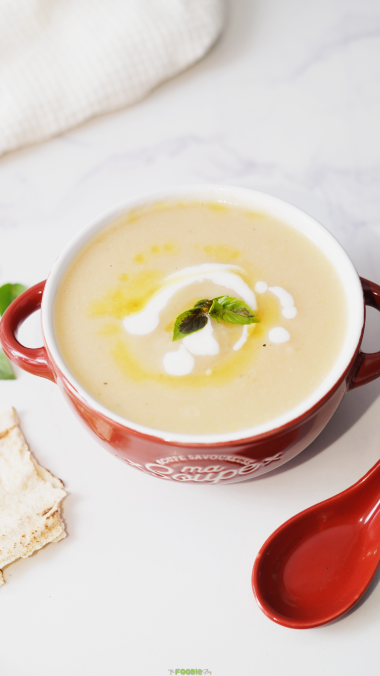 Bowl of creamy cauliflower soup topped with cream, olive oil, and fresh herbs. Bowl of creamy cauliflower soup topped with cream, olive oil, and fresh herbs.