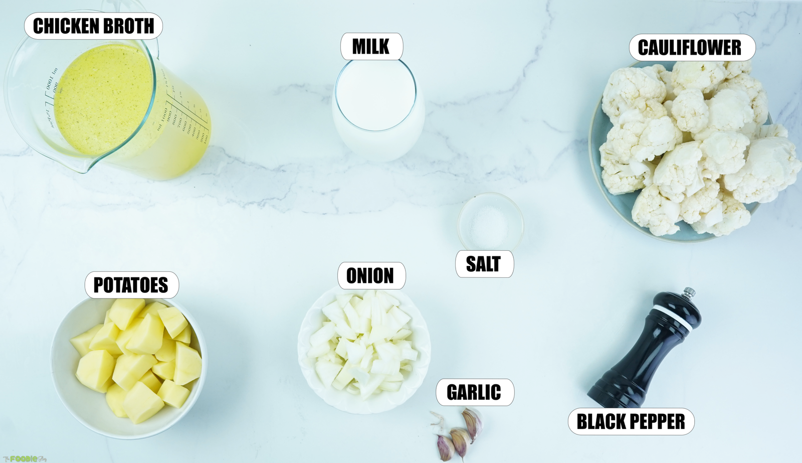 Ingredients for creamy cauliflower soup including cauliflower, potatoes, onion, garlic, milk, chicken broth, salt, and black pepper.