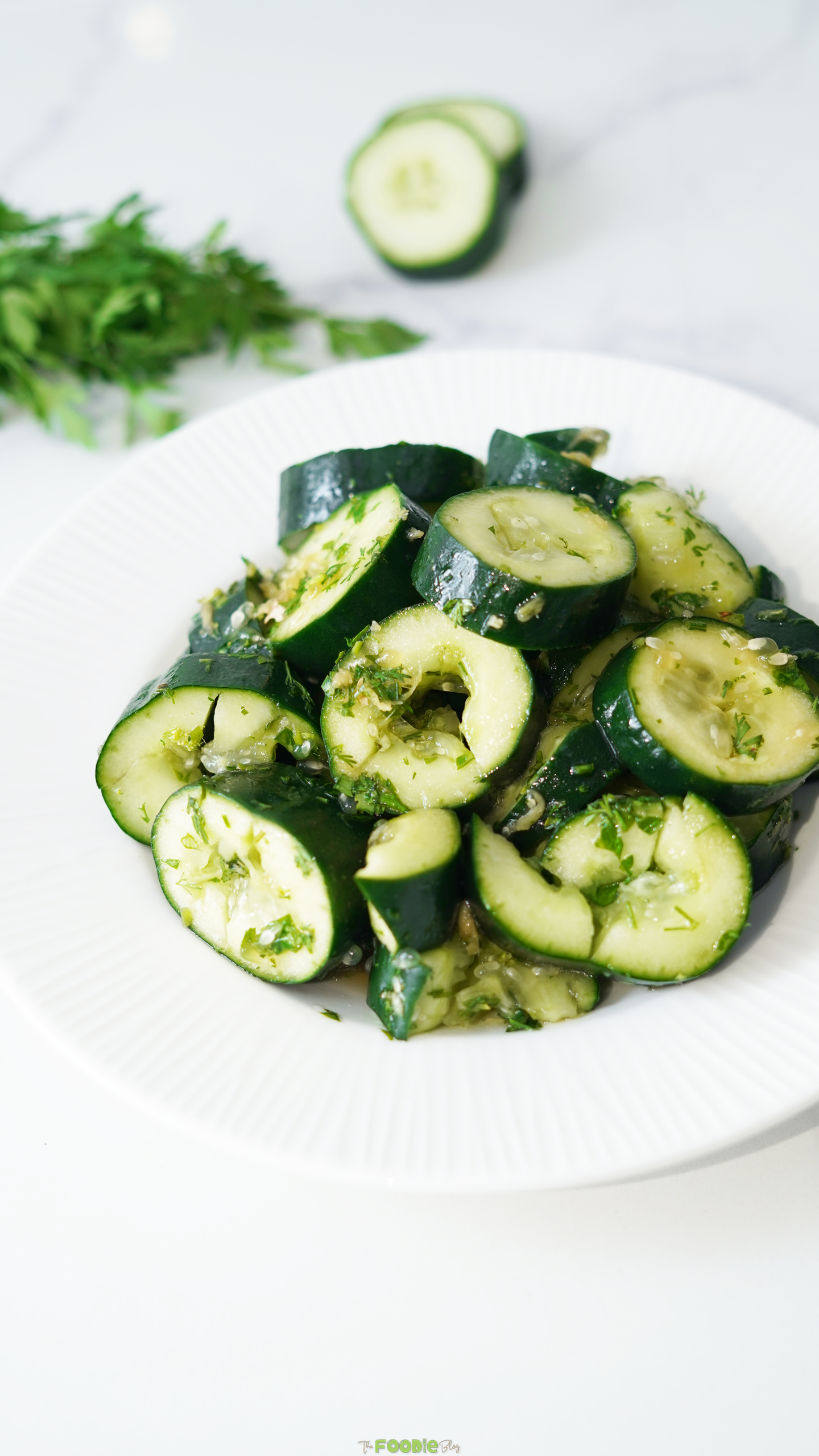 Close-up of smashed cucumbers with cilantro, ginger, soy sauce, and sesame dressing.