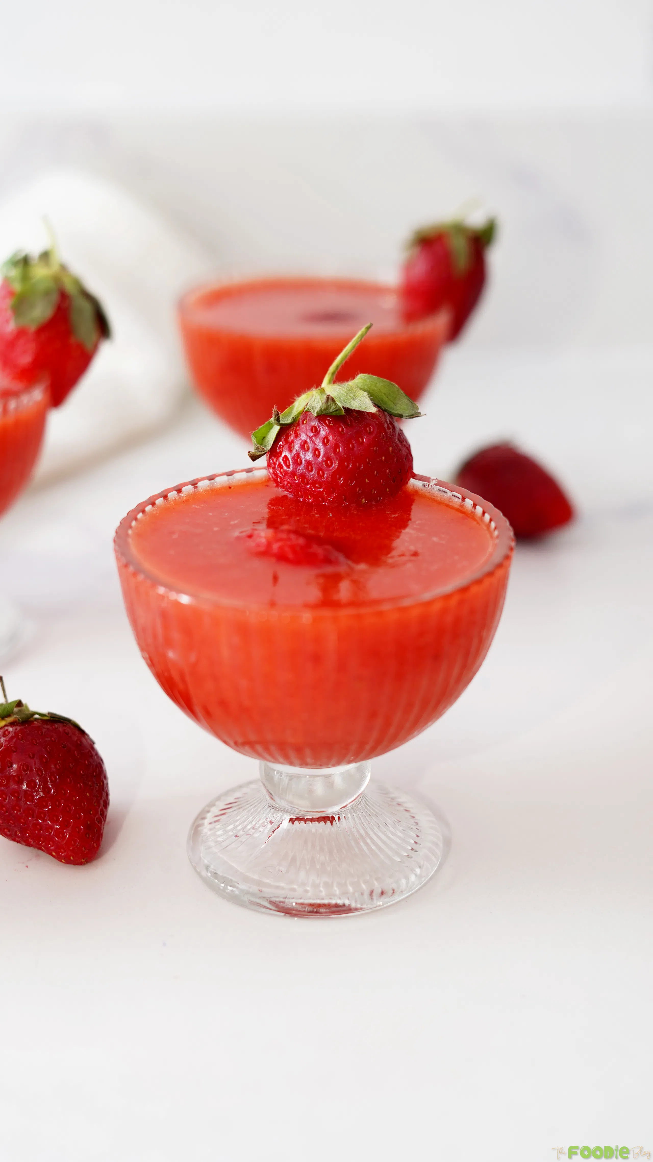 Close-up of a frozen strawberry daiquiri topped with a fresh strawberry.