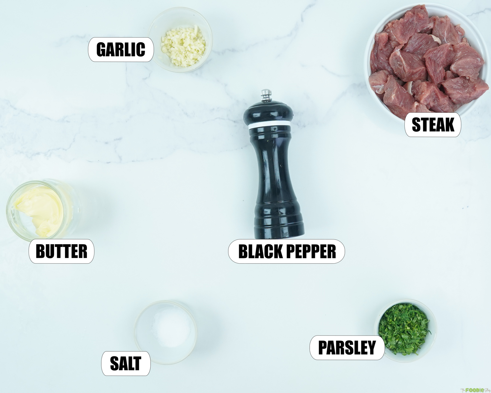Ingredients for Garlic Butter Steak Bites including steak, garlic, butter, black pepper, salt, and fresh parsley.
