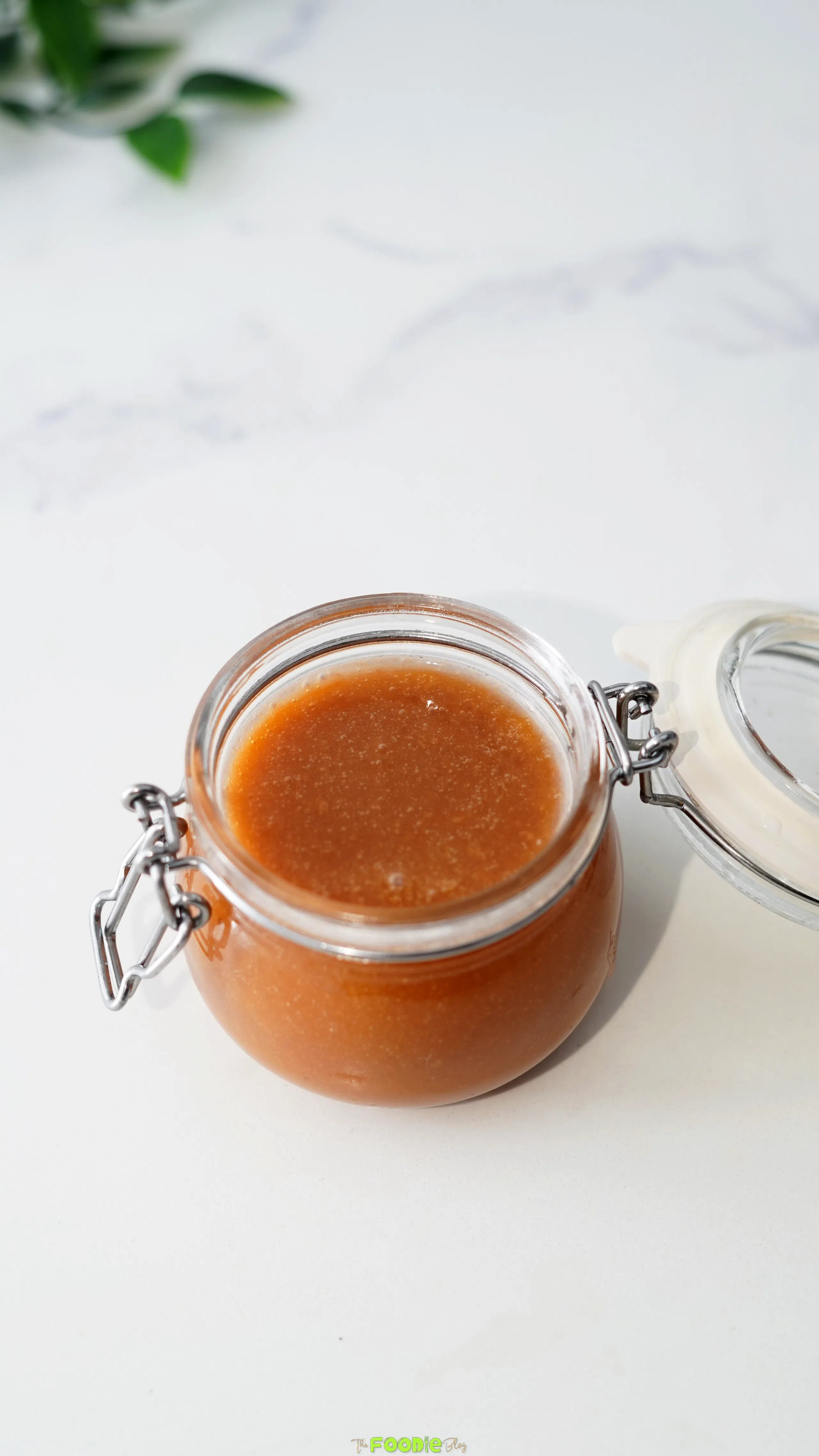 Open glass jar filled with smooth homemade caramel sauce