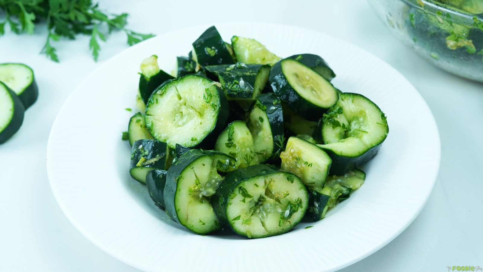 Smashed cucumber salad tossed with cilantro and sesame ginger dressing in a white bow