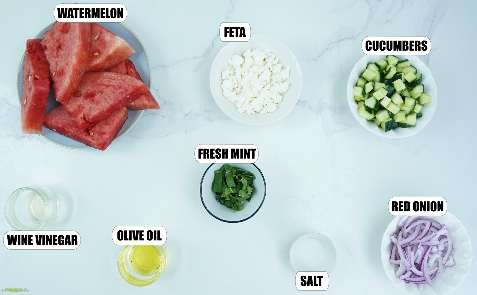 Ingredients for watermelon feta salad with watermelon, feta, cucumber, mint, red onion, olive oil, vinegar, and salt.