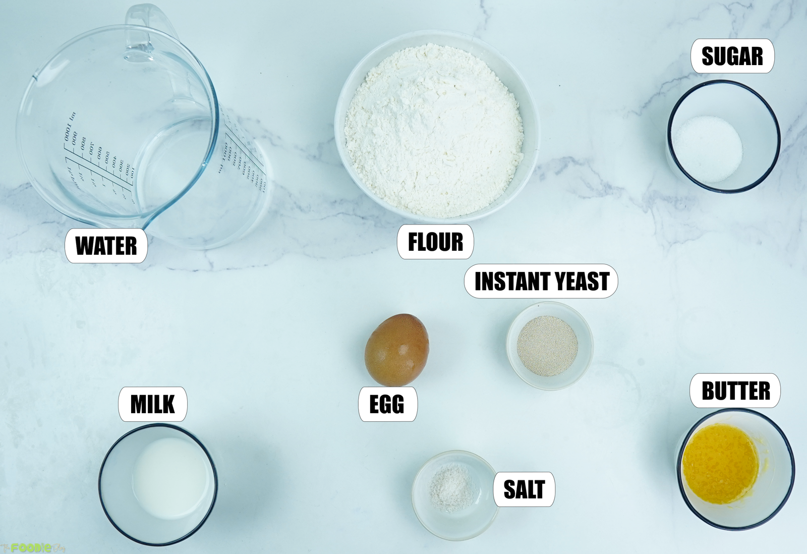 Flour, warm water, milk, egg, instant yeast, sugar, salt, and melted butter arranged for homemade cheese naan.