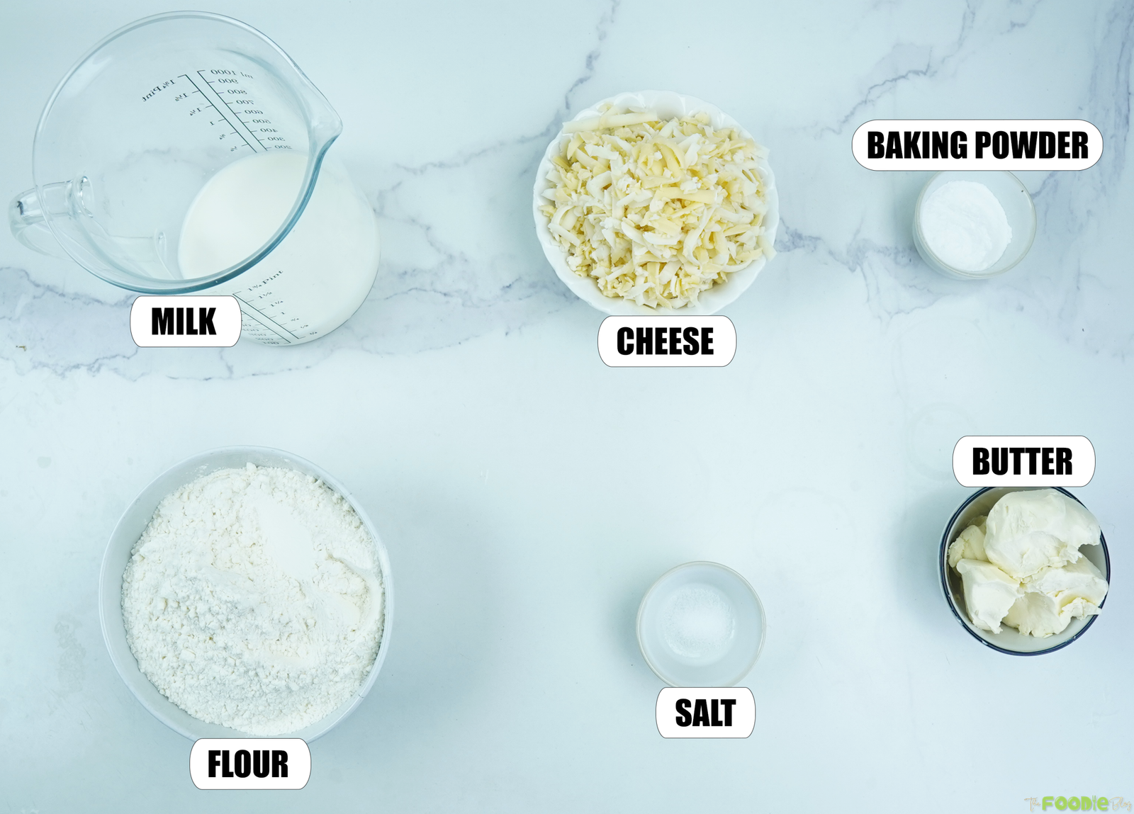 Ingredients for Cheese Scones with milk, shredded cheese, baking powder, flour, salt, and butter.