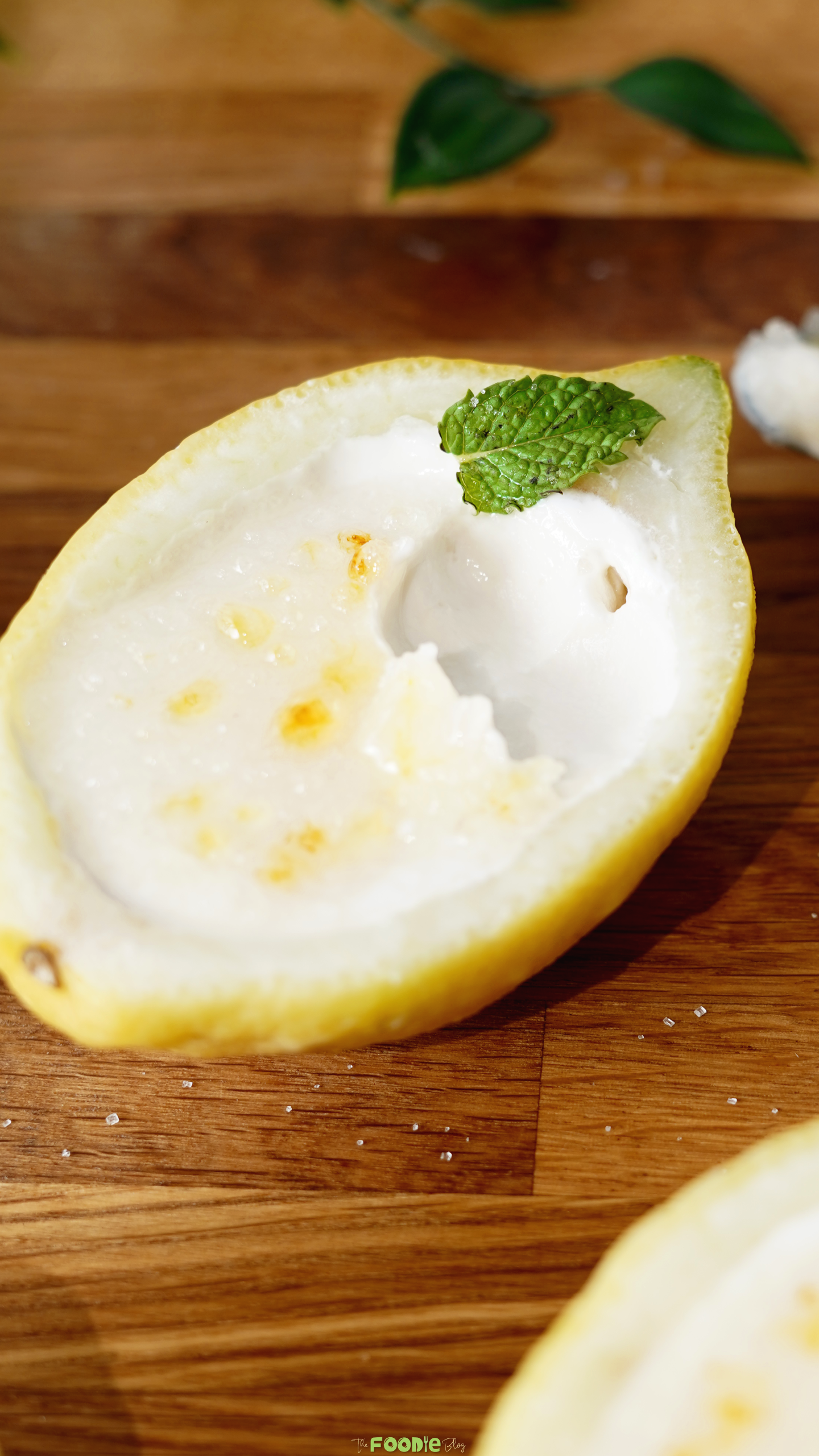Spoonful removed from lemon posset brûlée showing the smooth, creamy filling inside a lemon shell.